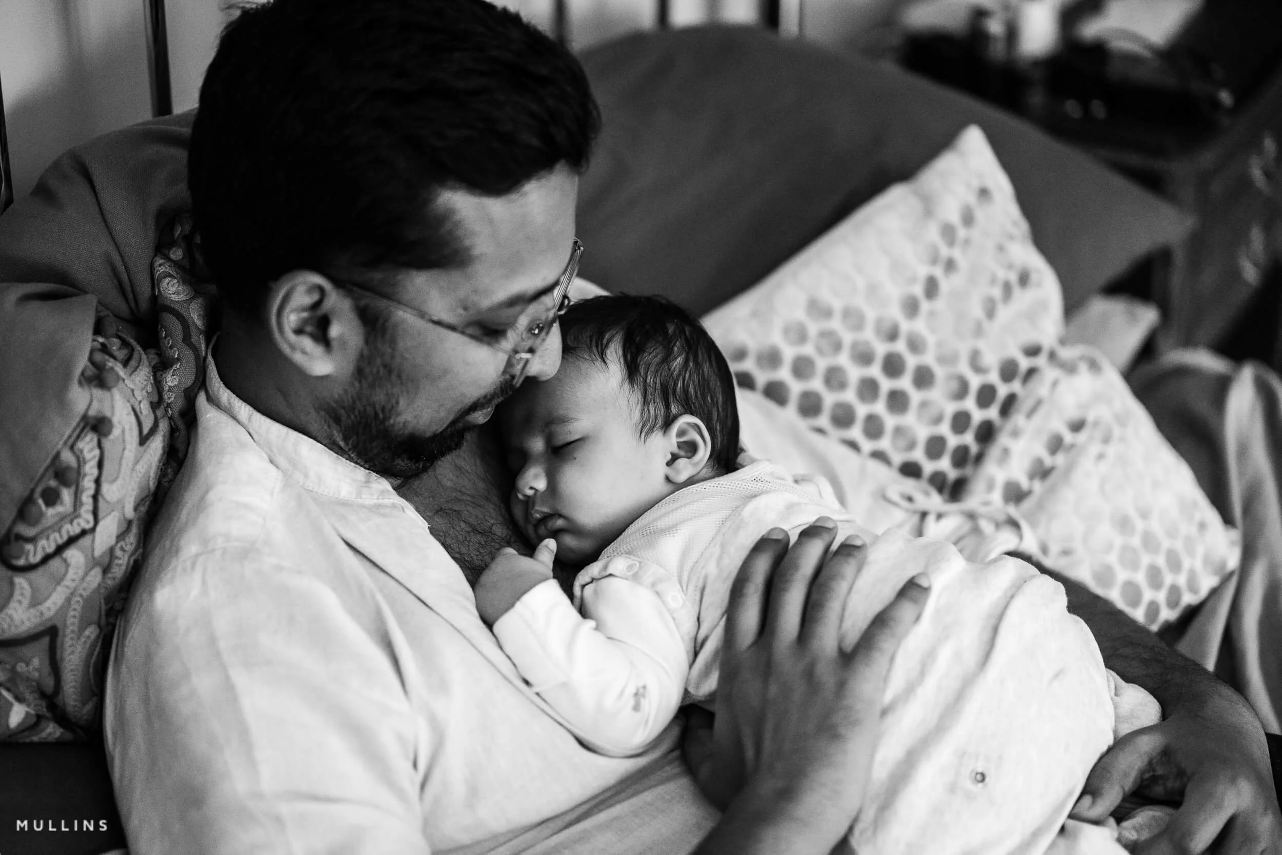 a father holds his new born baby