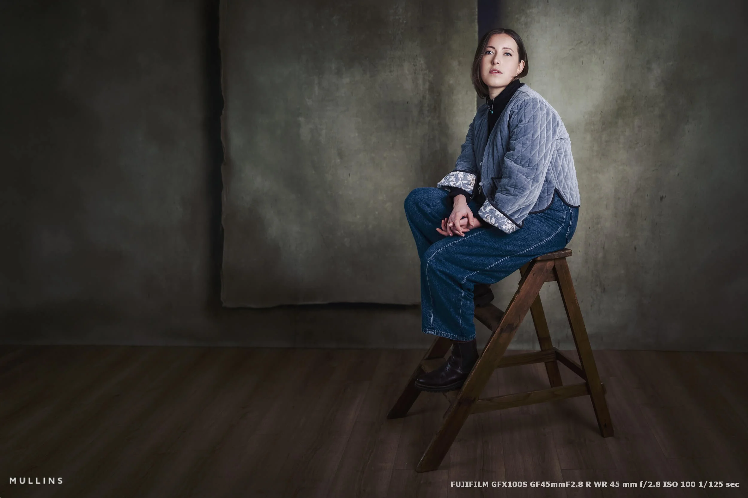 Portrait of a youg woman sat on a stool taken with the Fuji GF45mm Lens.