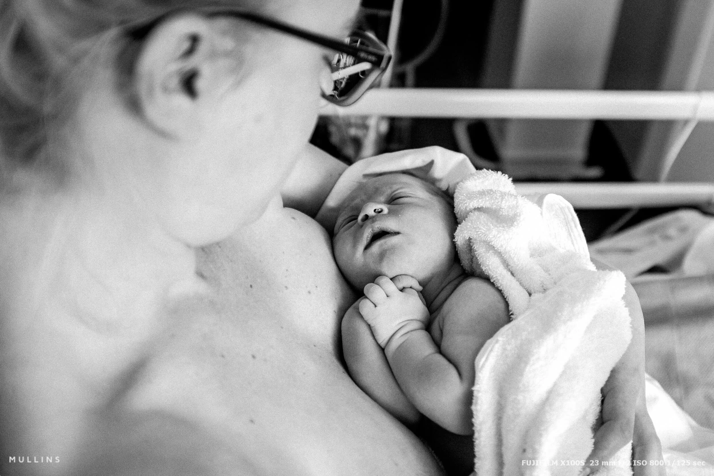 A mother holding her new born baby in a maternity ward