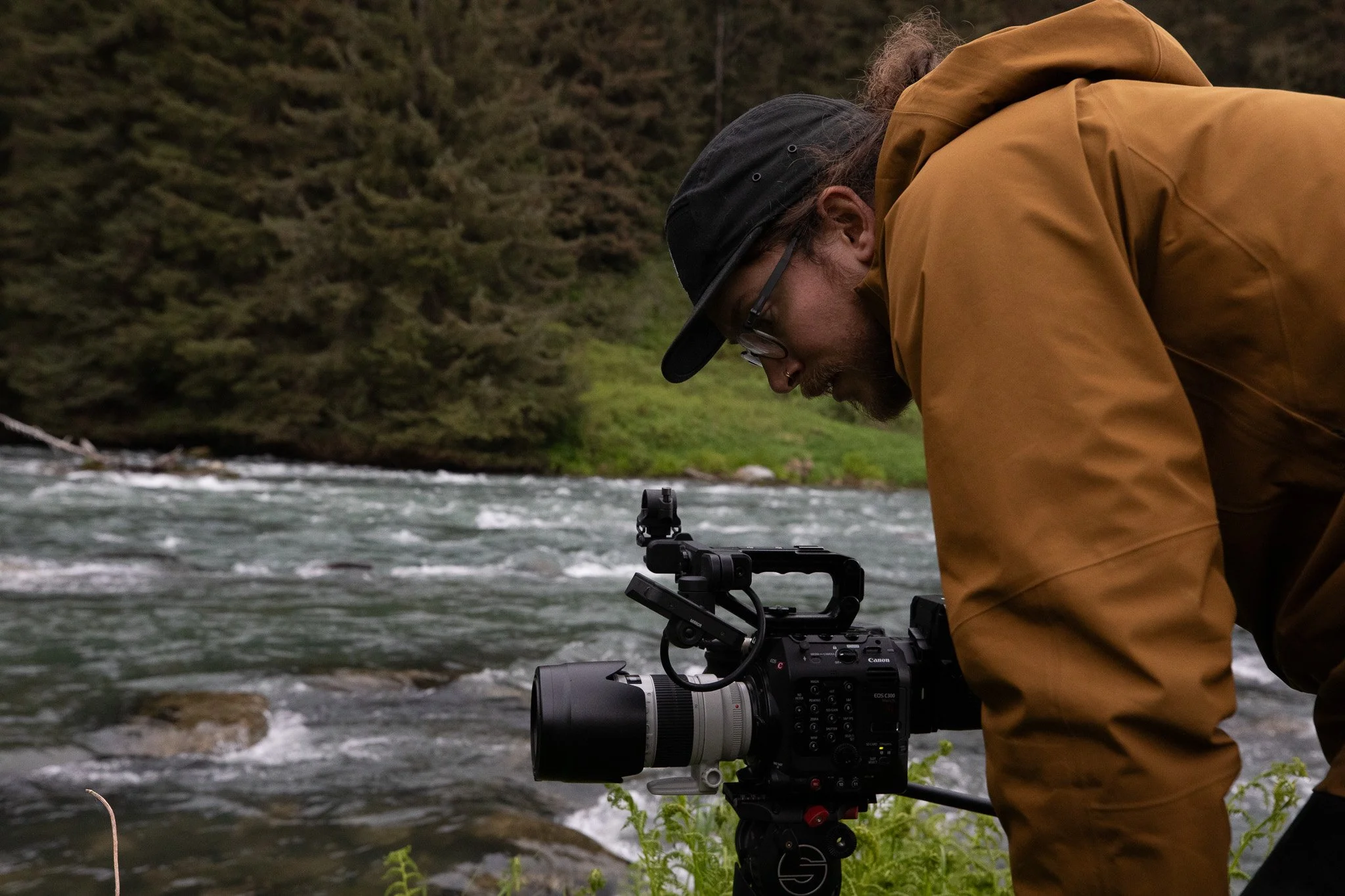Videographer closely looking at camera to get the right shot to make post production easy!