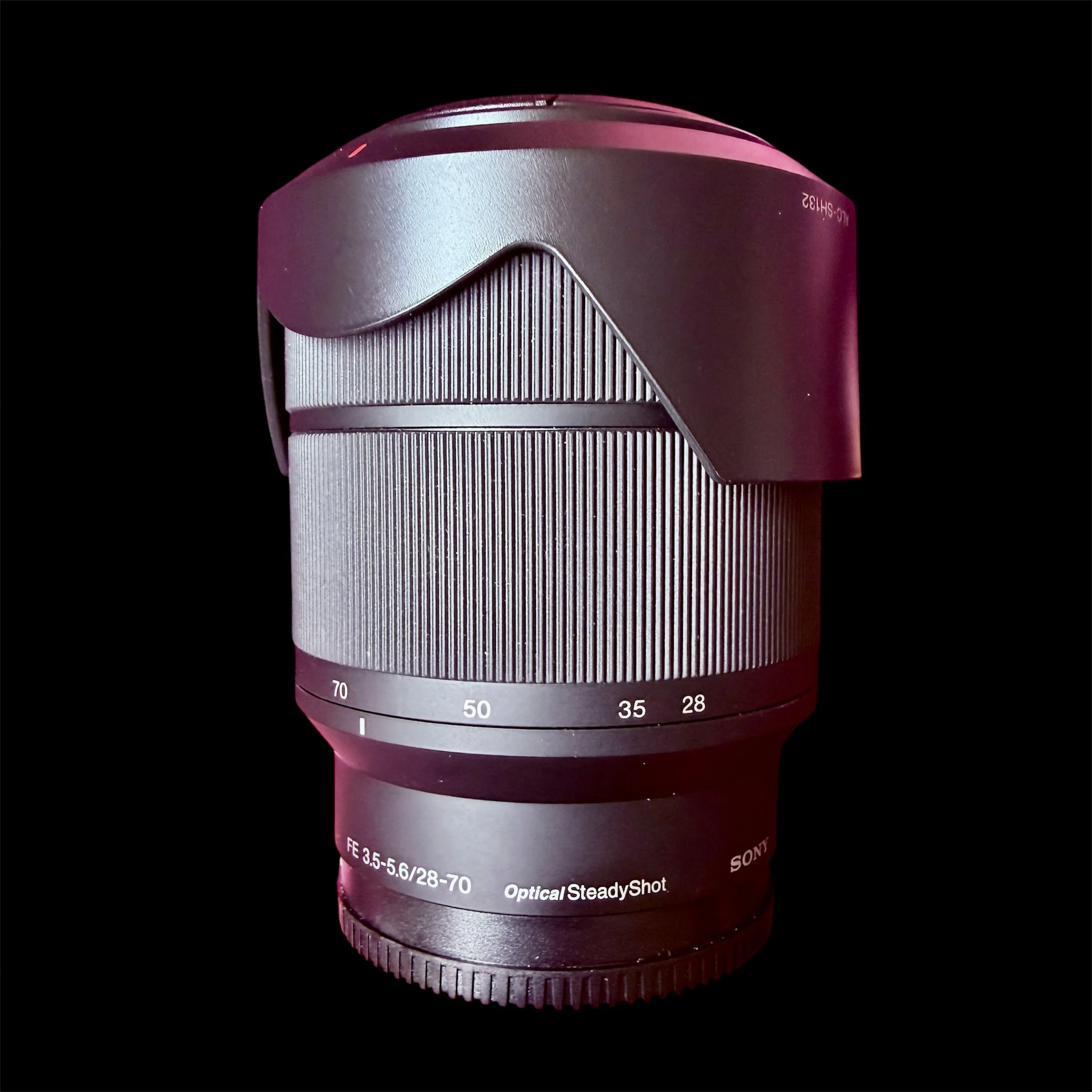 Close-up of a camera lens with focus and aperture settings visible, showing the markings and details on the lens barrel.
