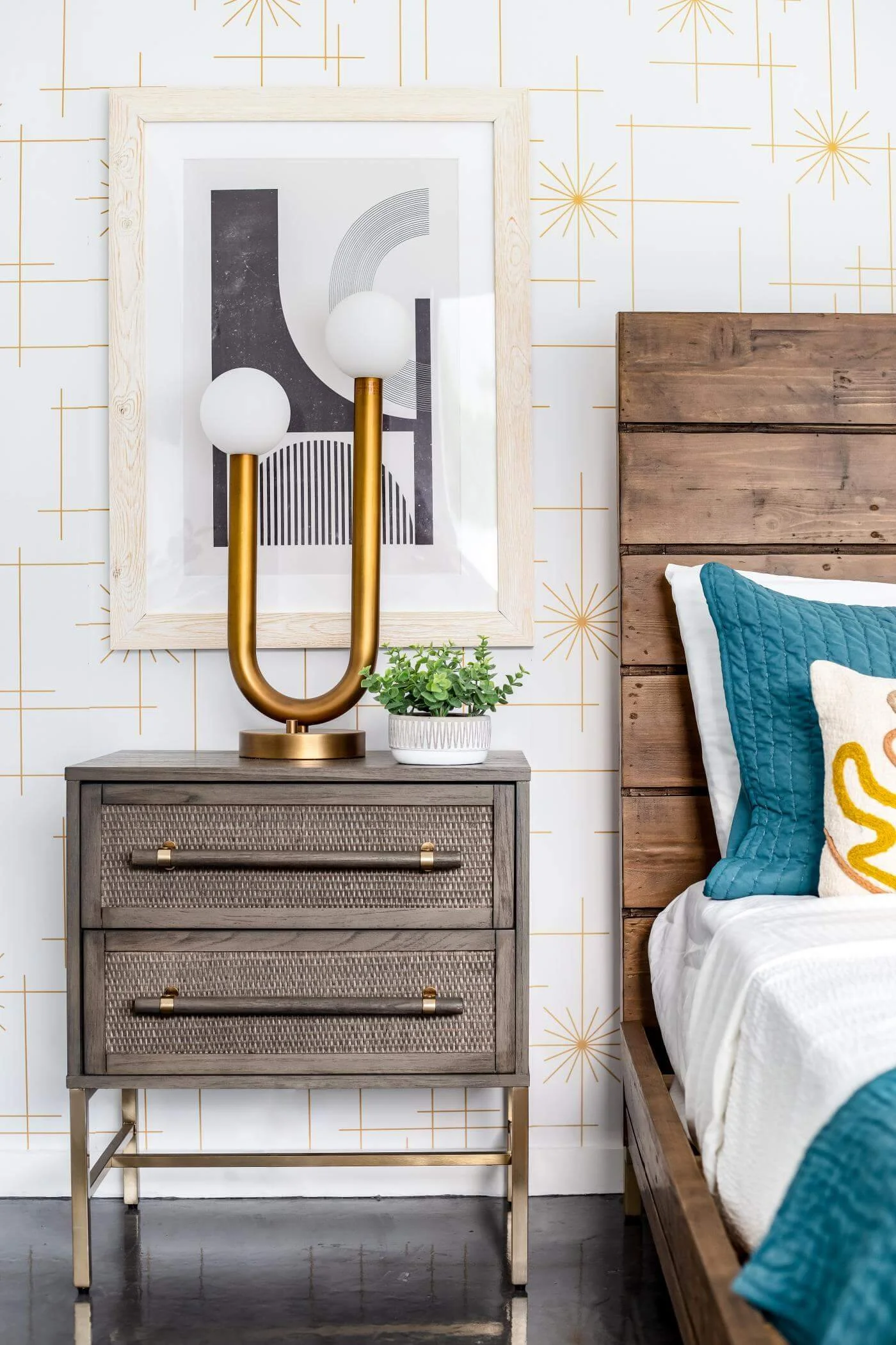 rattan nightstand with glam wallpaper and black and white abstract art