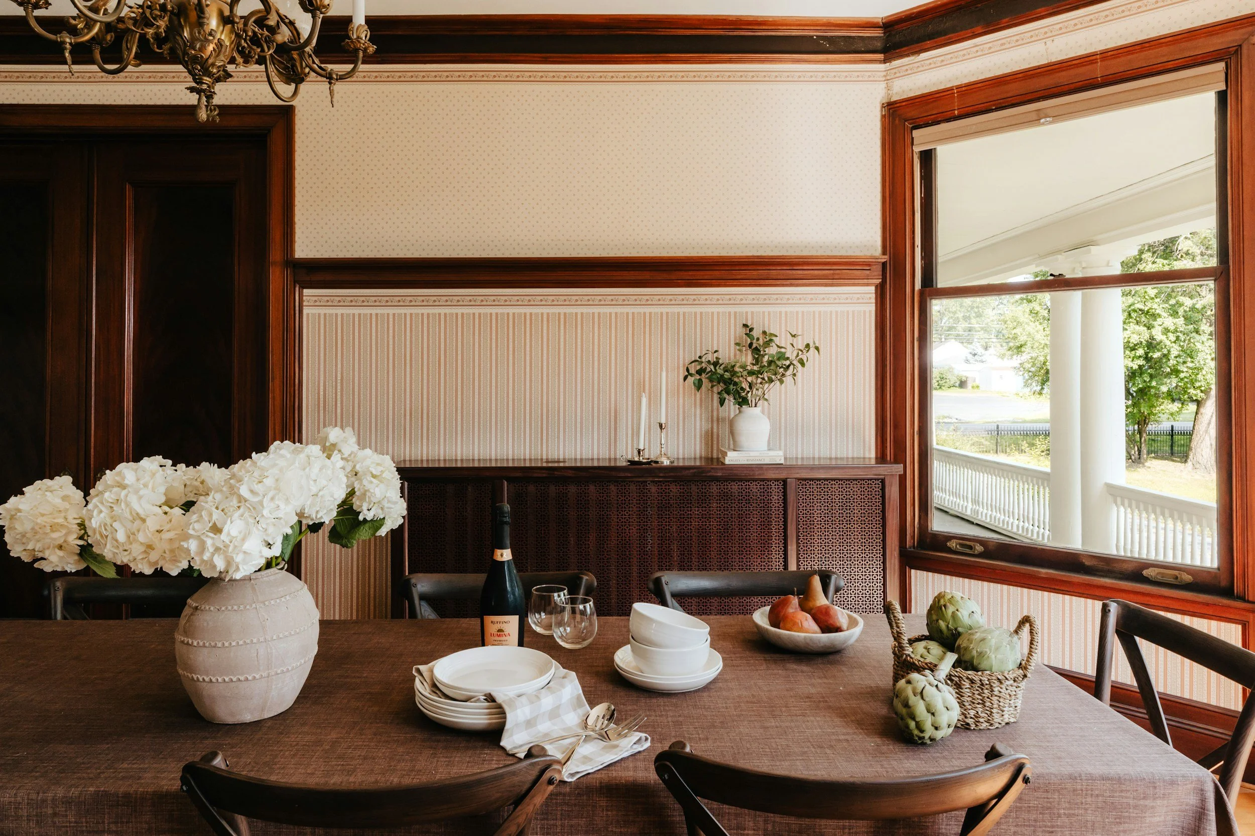 walnut dining table with white flowers in a vase