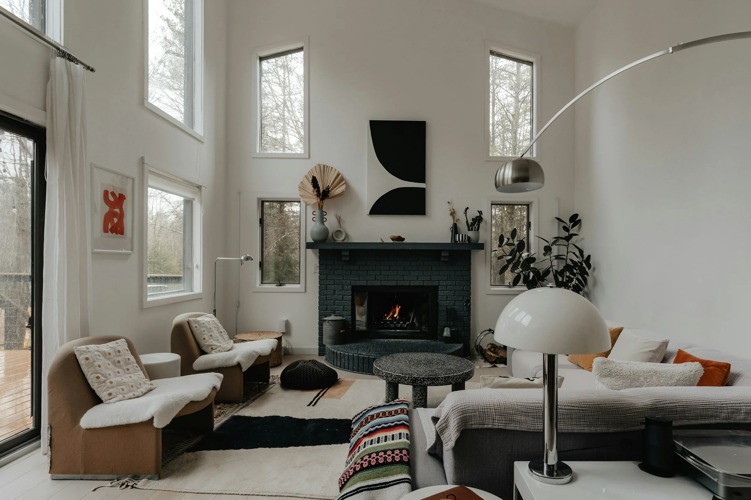 living room with white walls tall ceilings and a blue brick fireplace