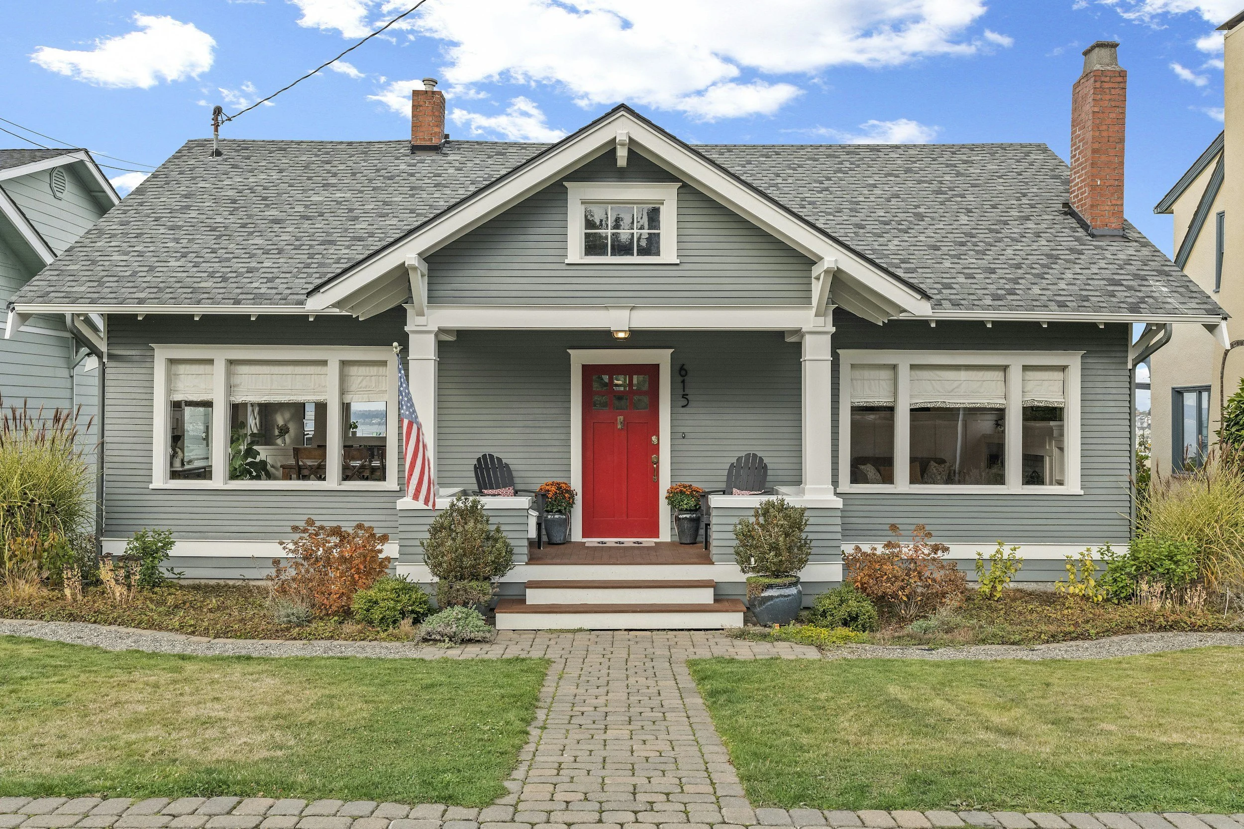 gray house with red door and american flag