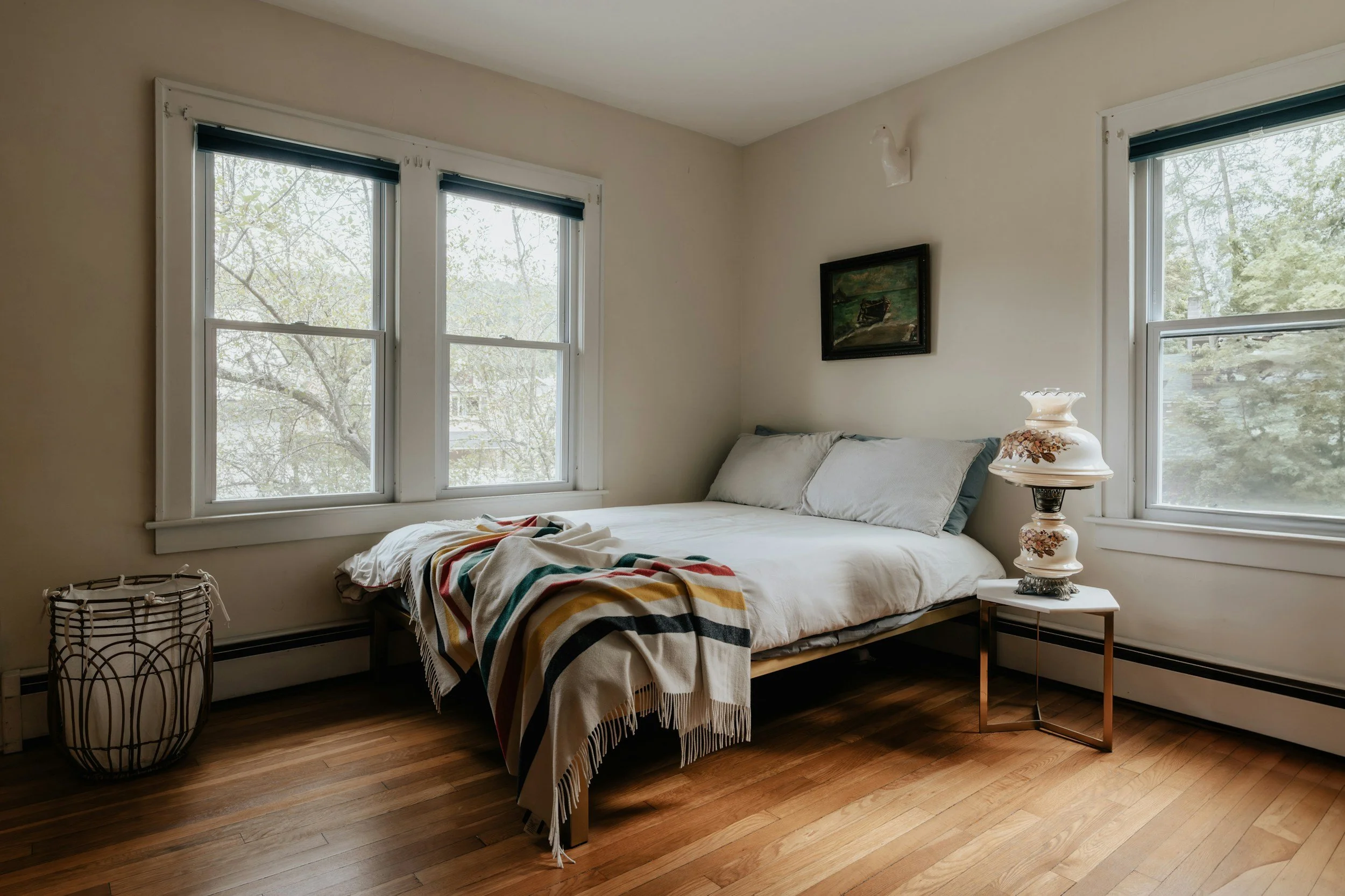 minimal bedroom with a pendleton blanket and vintage table lamp