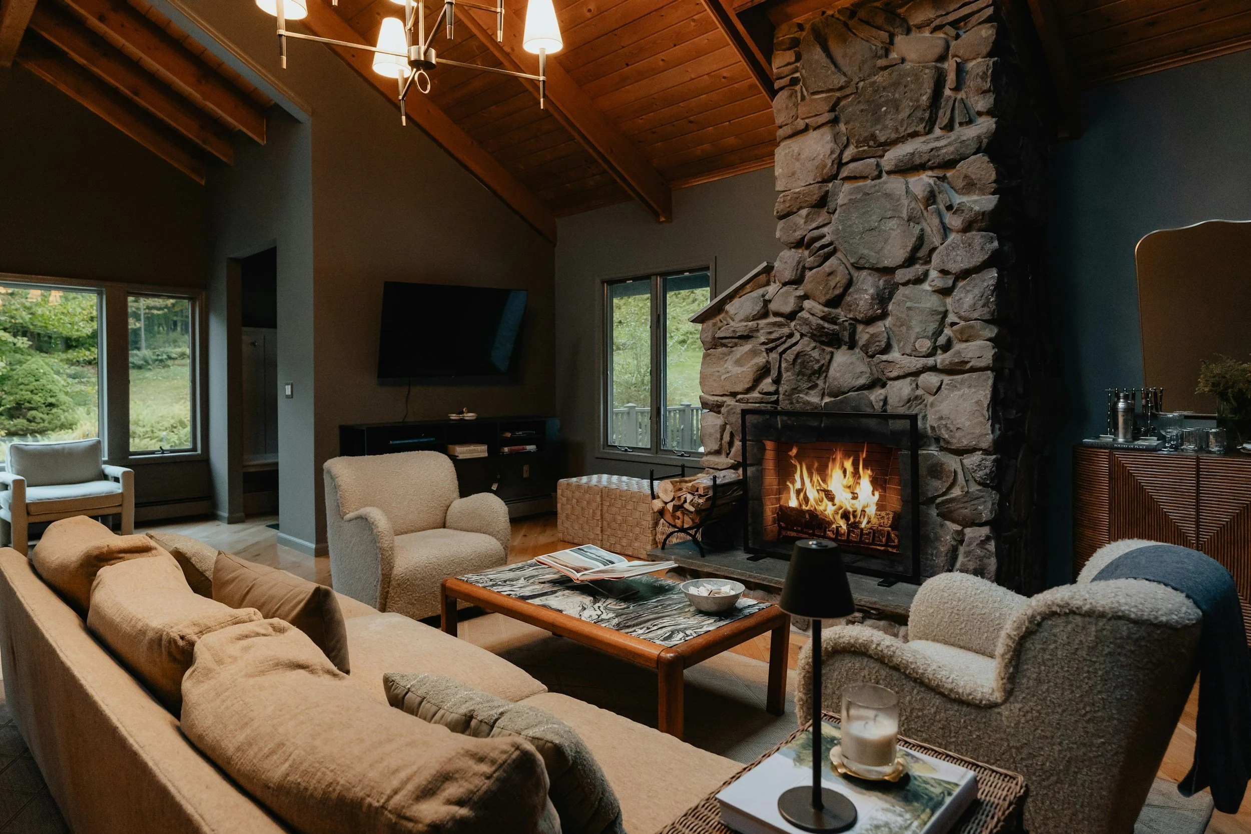 moody living room with stone fireplace and blue walls