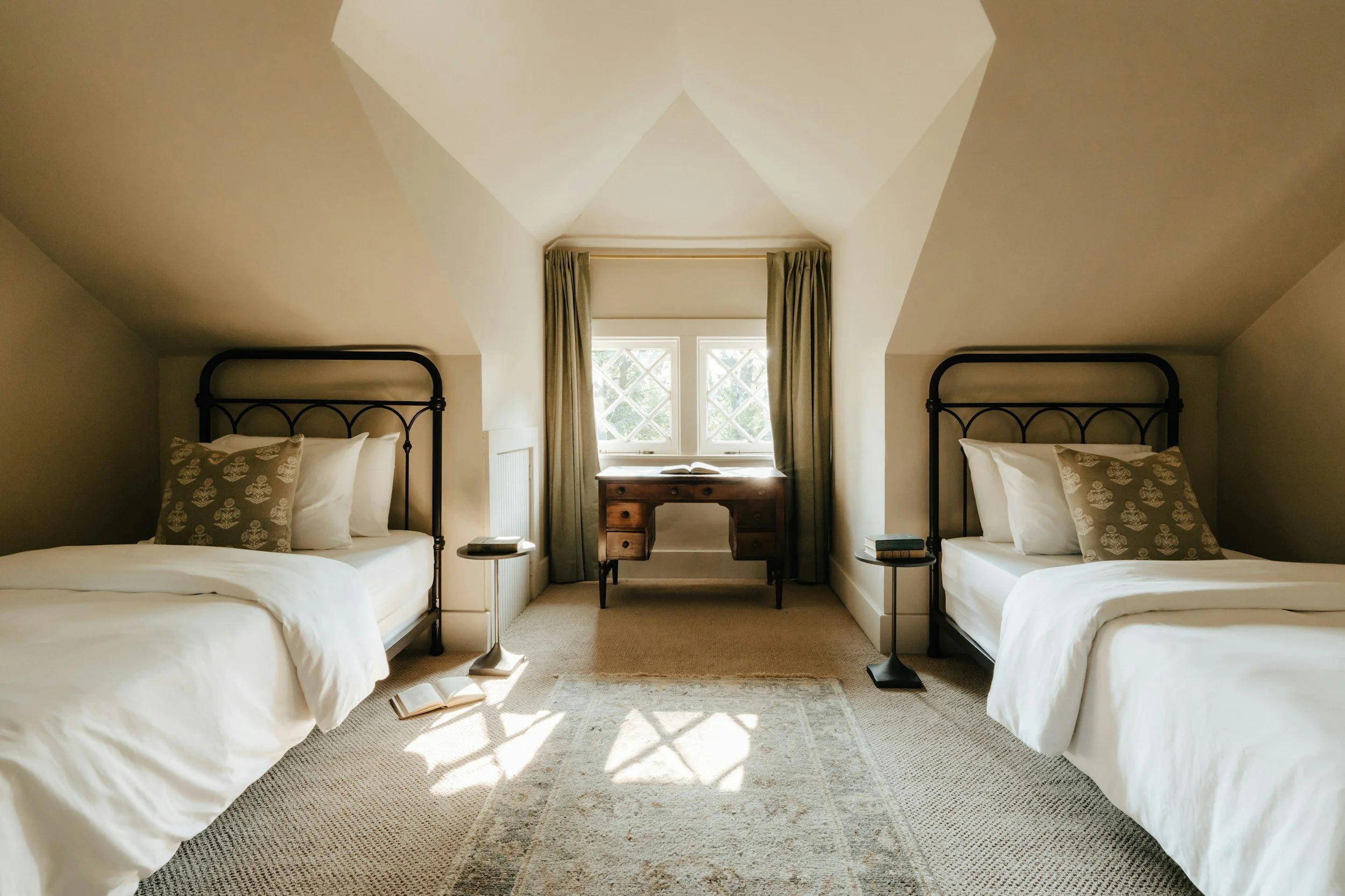 black twin beds with green throw pillows