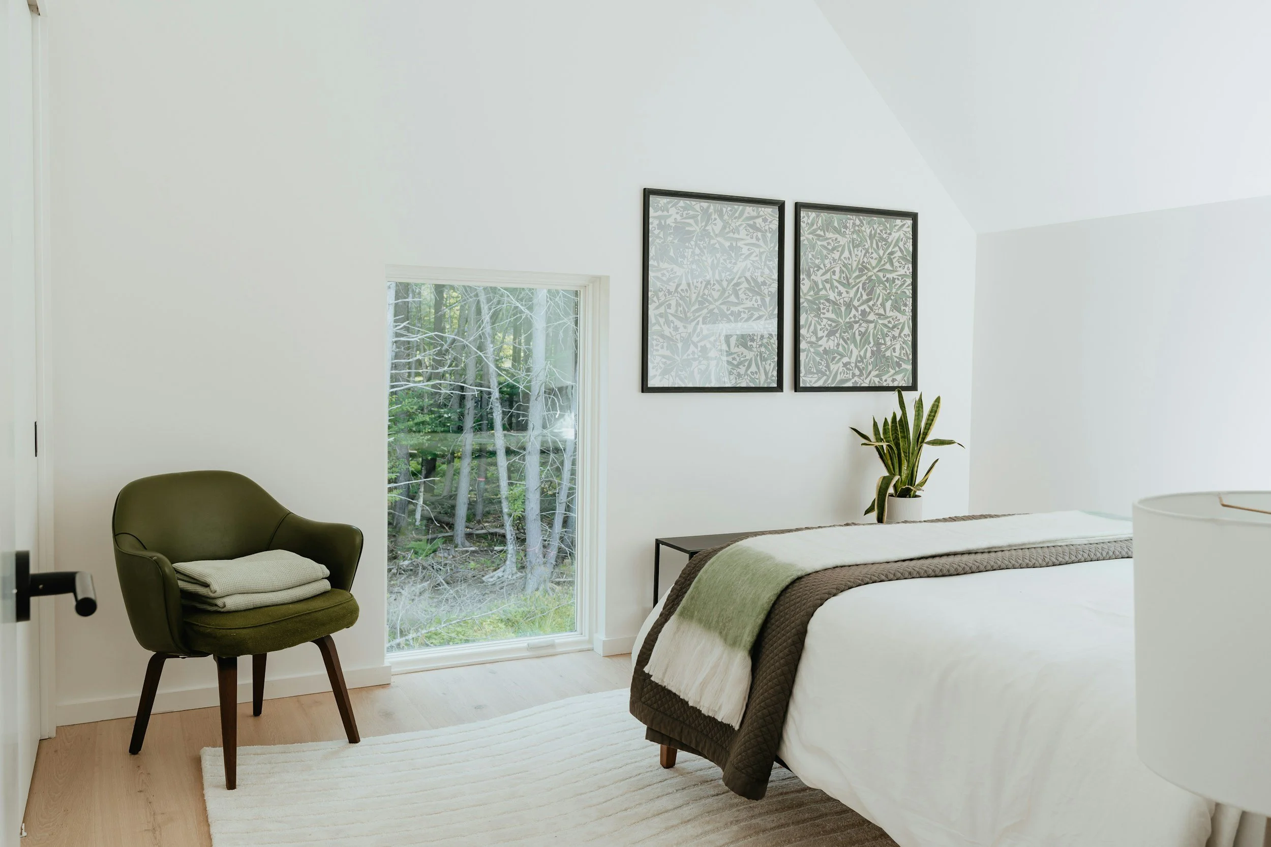 minimalist bedroom with white walls and green chair