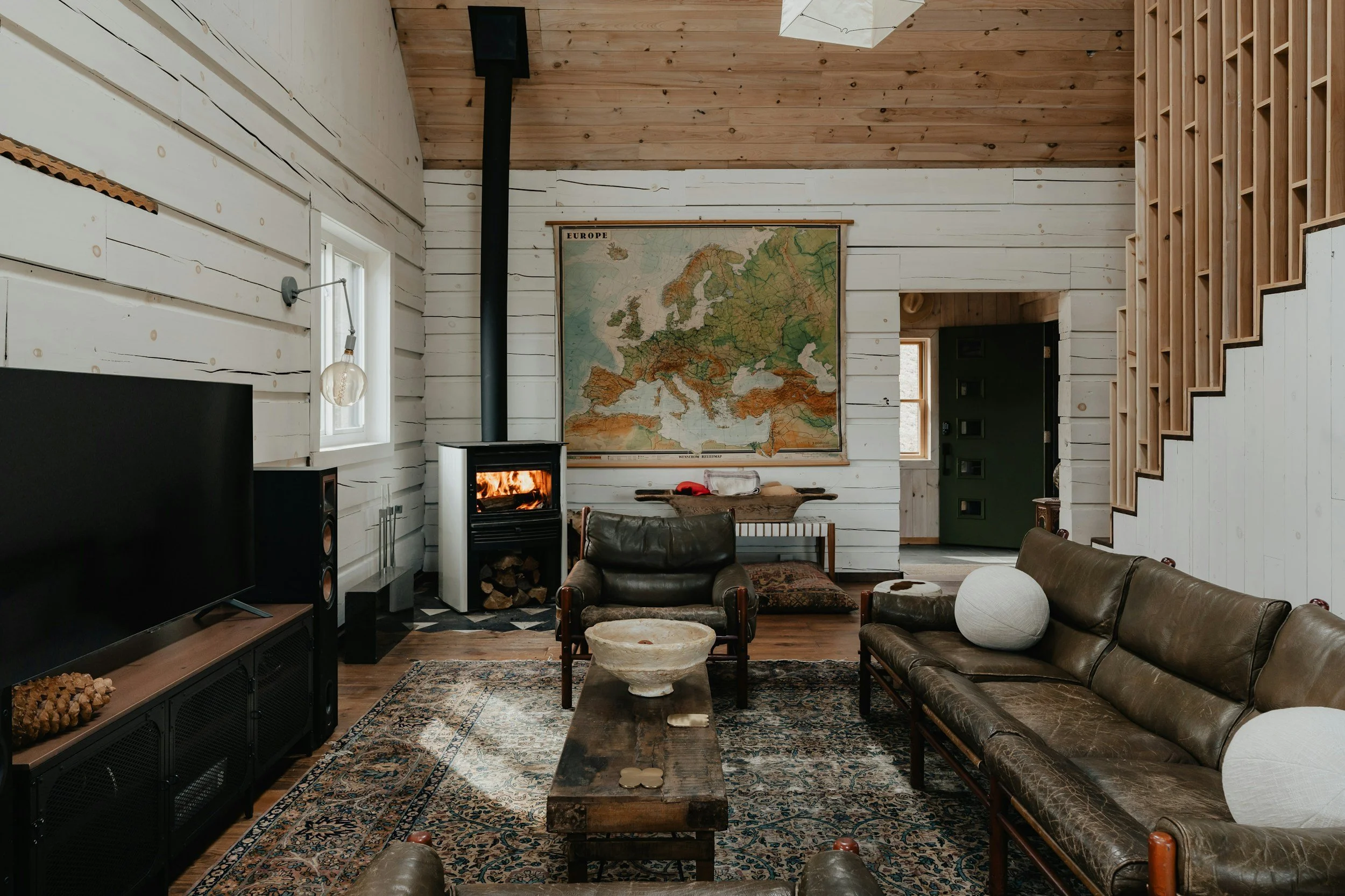 living room with vintage green leather sofa and wood burning stove