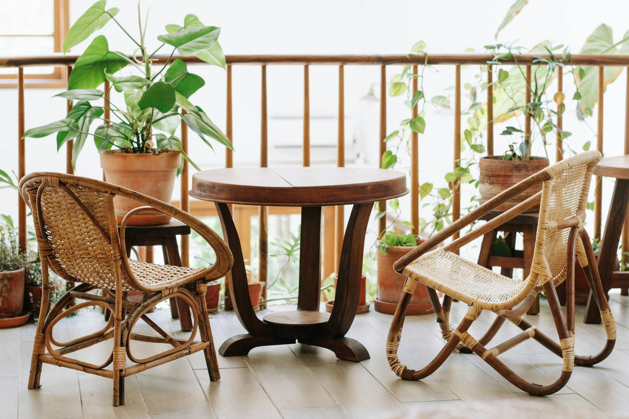 patio with potted plants and rattan chairs