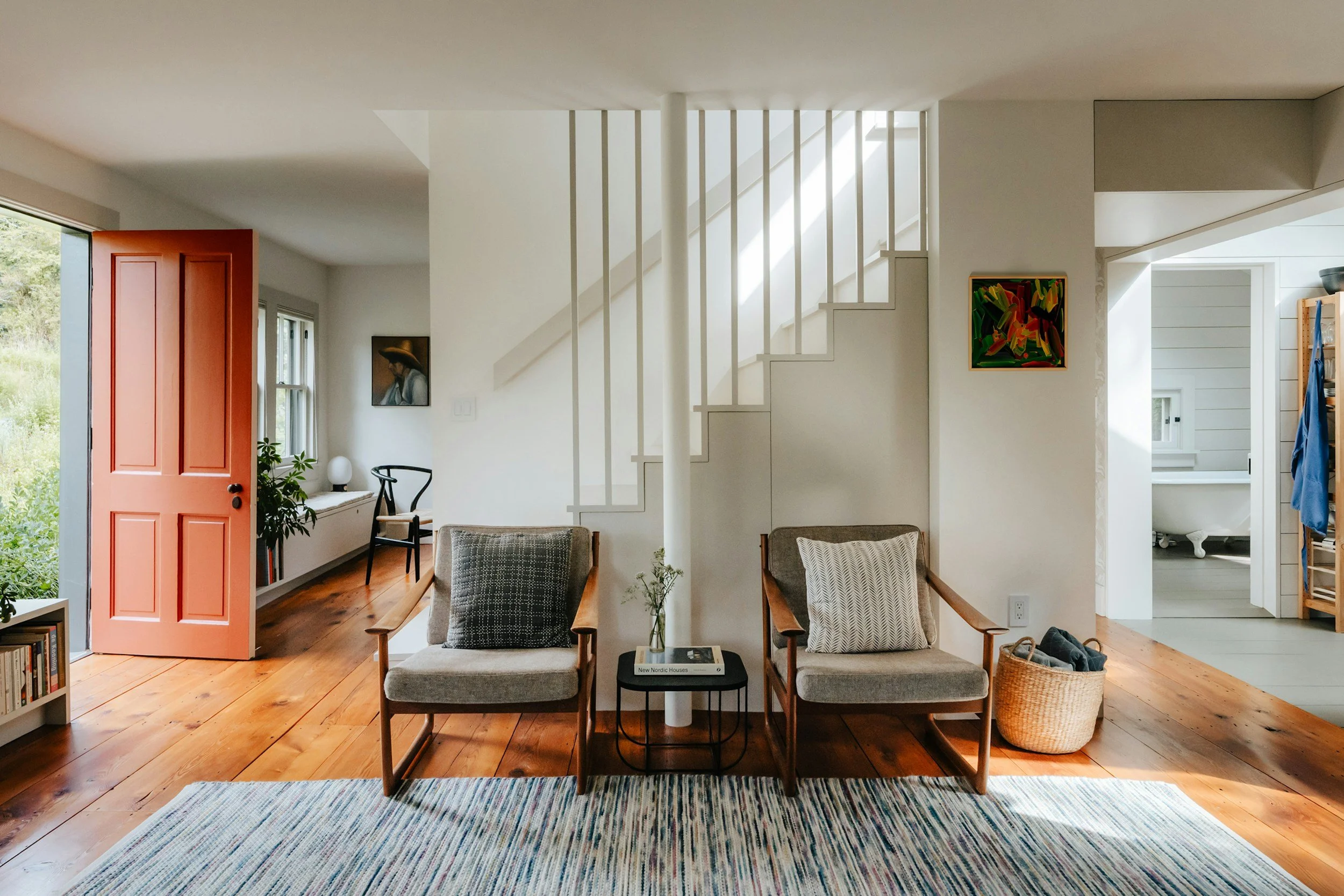 two gray chairs with mismatched throw pillows and a red door