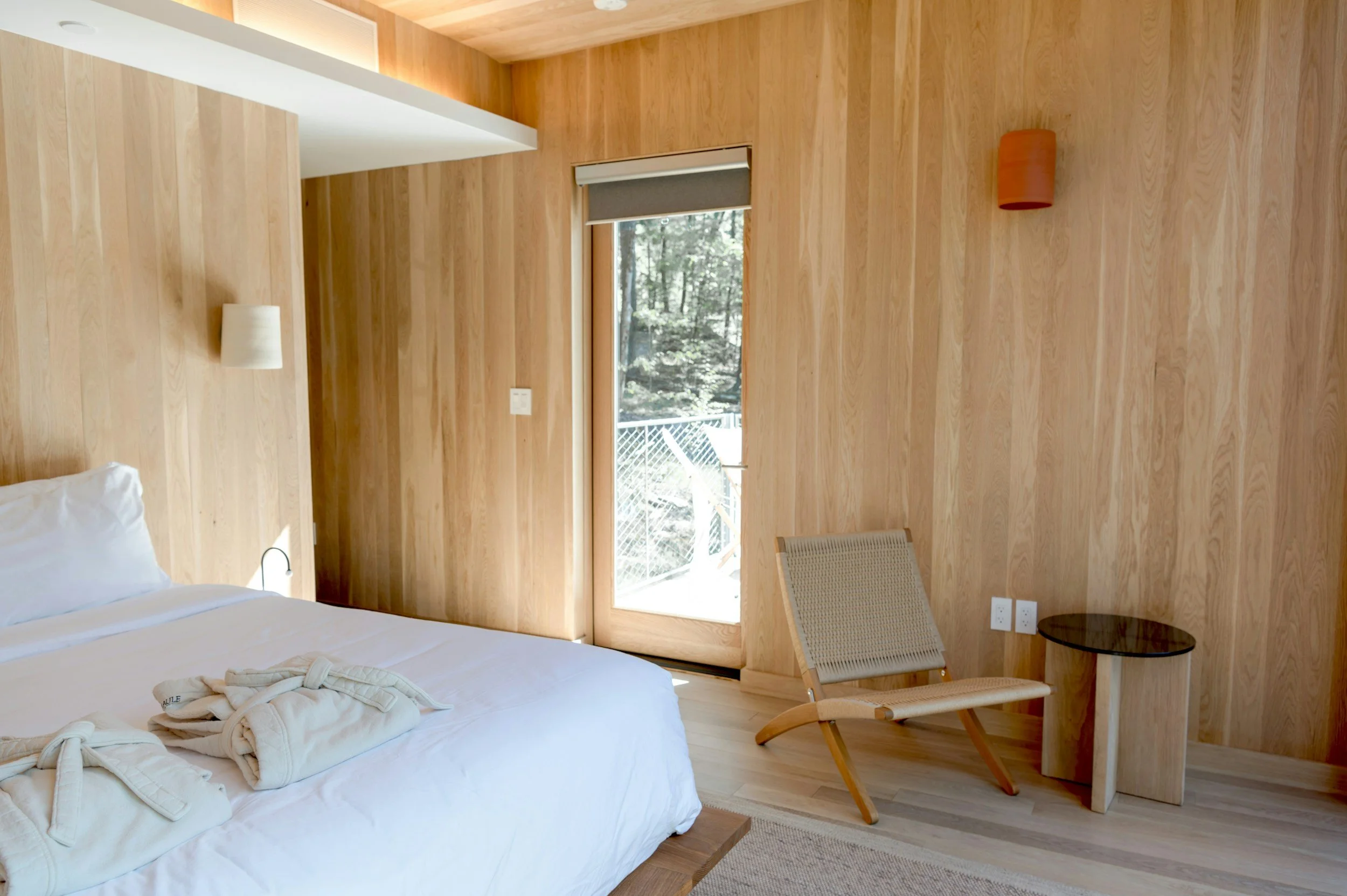 oak bedroom clad in wood walls and ceiling