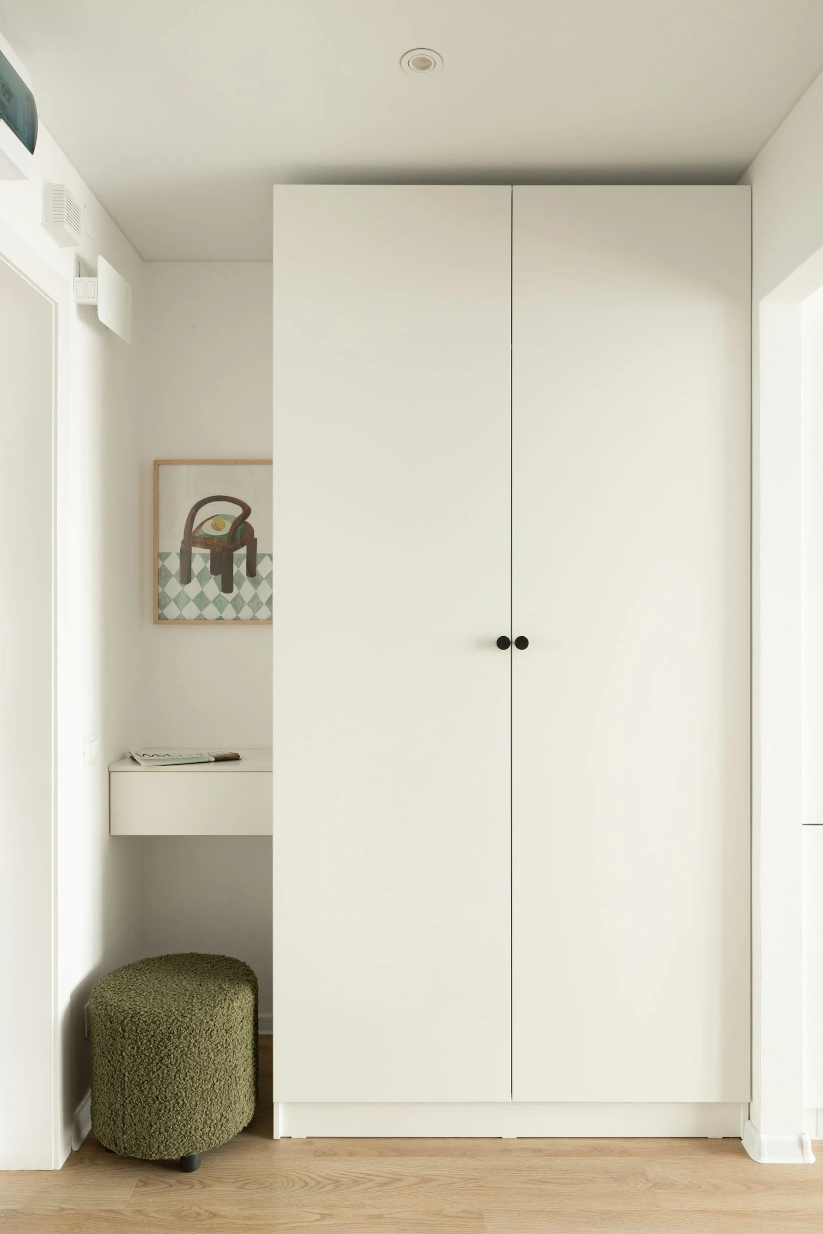 white closet with small vanity and green ottoman