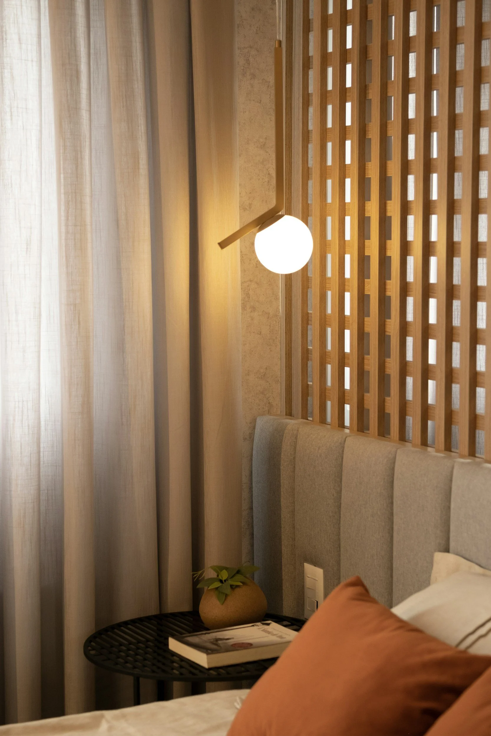 bedroom corner with wood texture accent wall and brass sconce