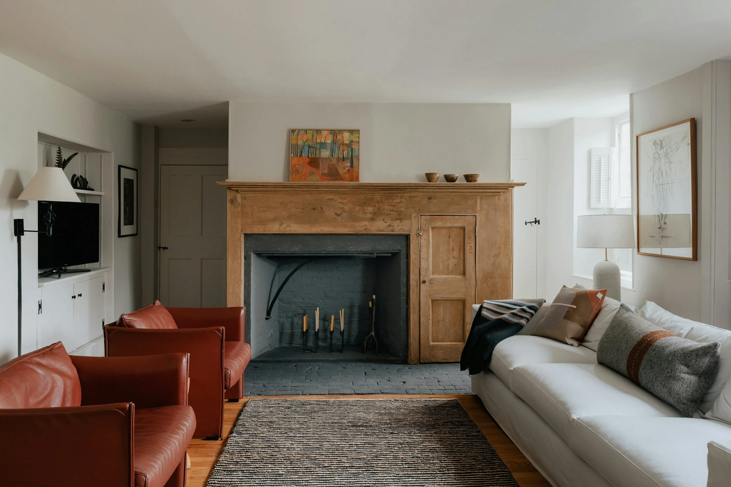 living room with red chairs and a wood fireplace