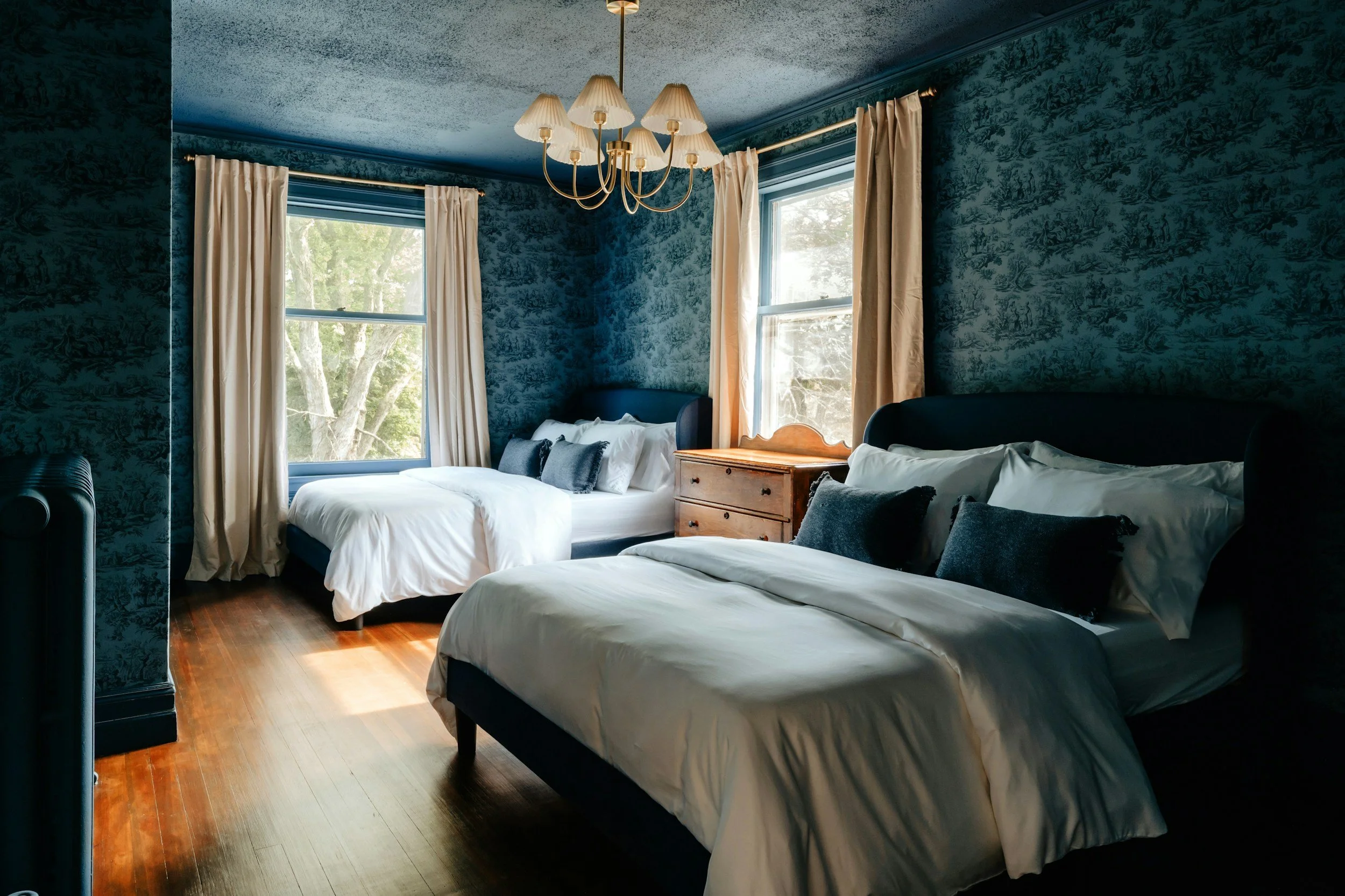 blue bedroom with floral wallpaper and white bedding