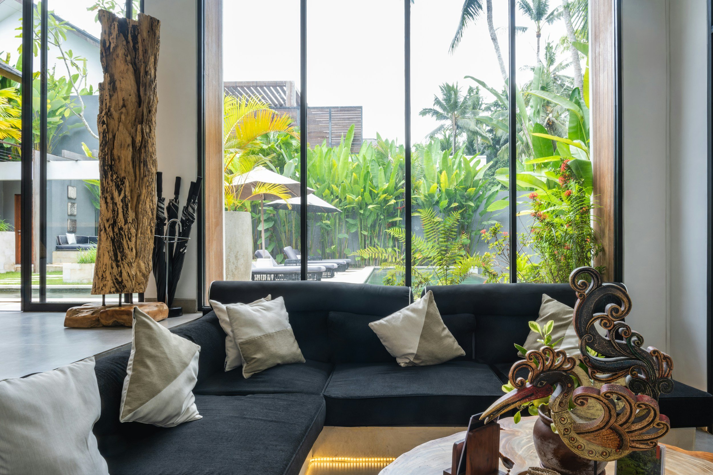 blue sofa in front of floor to ceiling windows