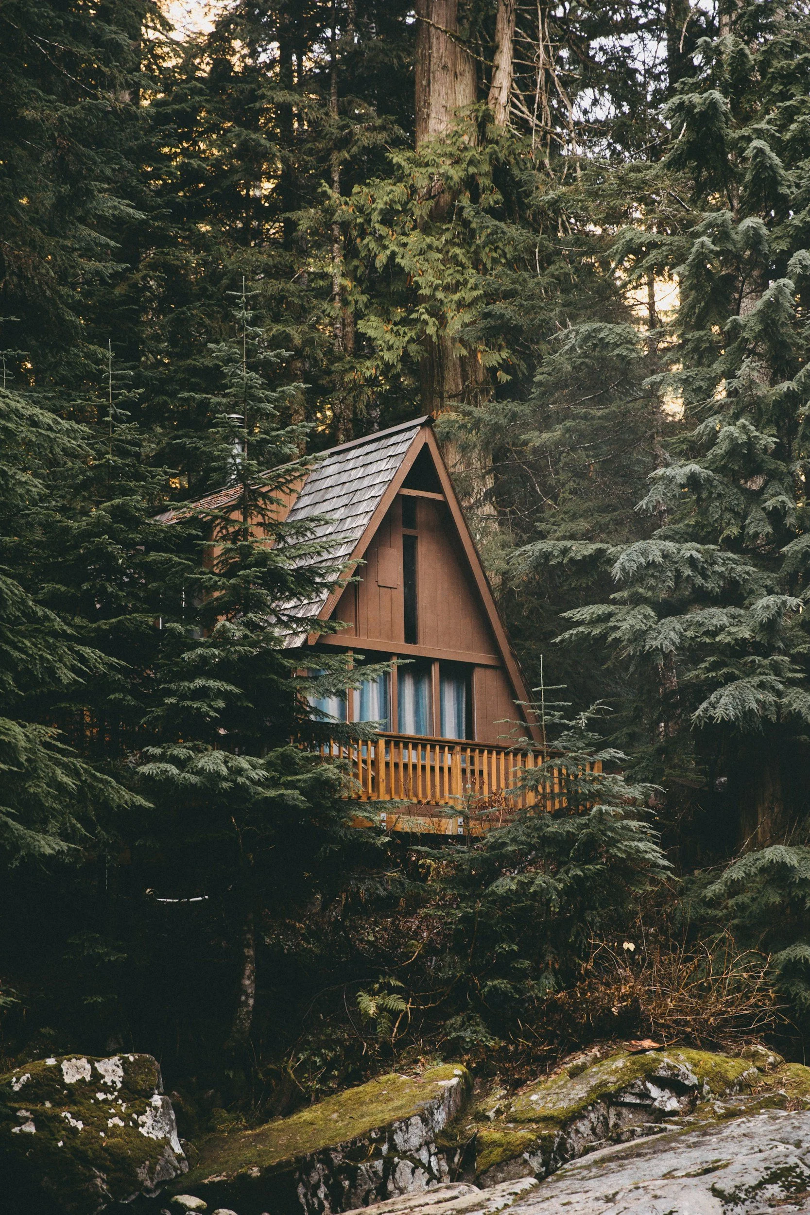 wood a-frame cabin tucked in the woods