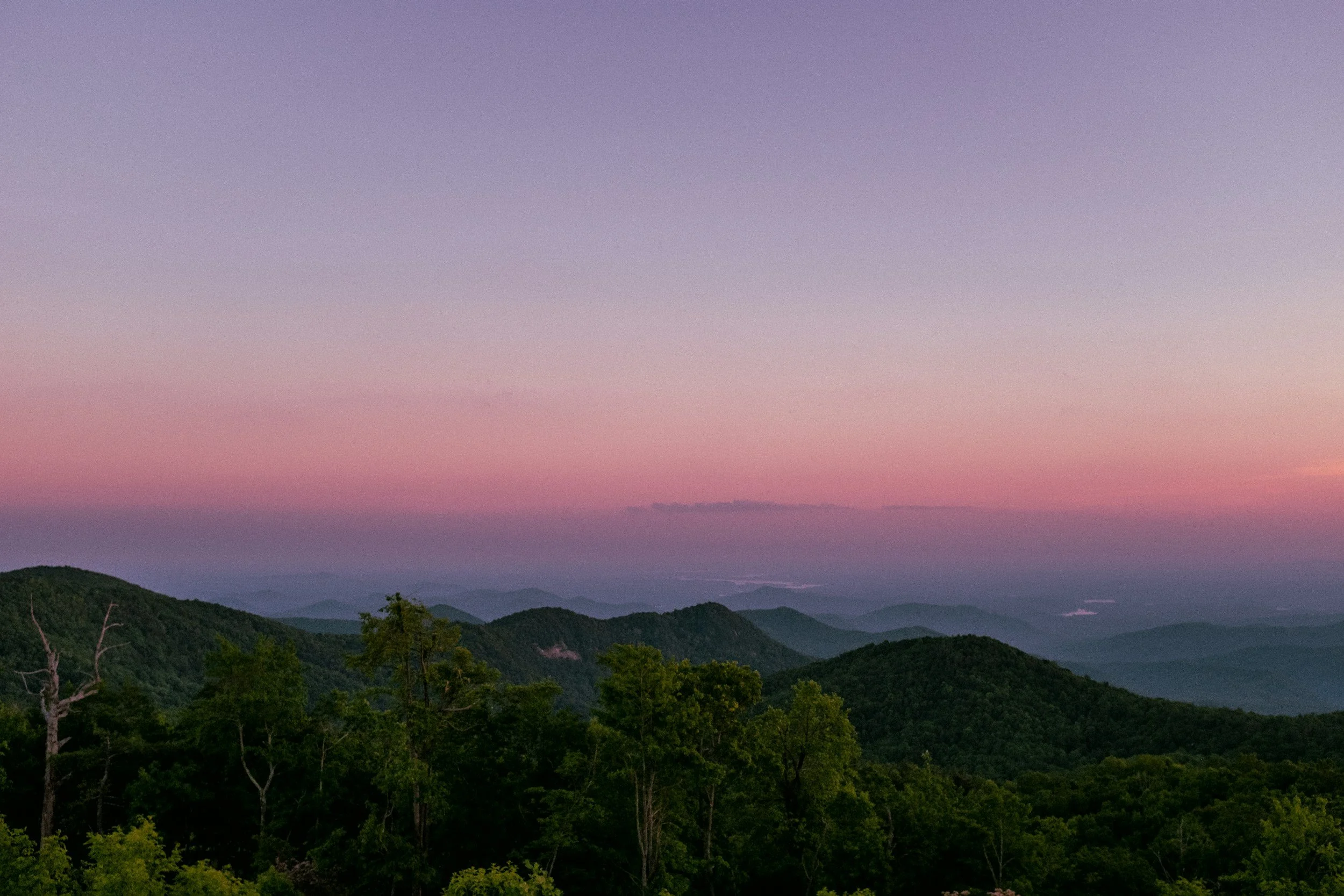 purple and pink sunset behind the blue ridge mountains