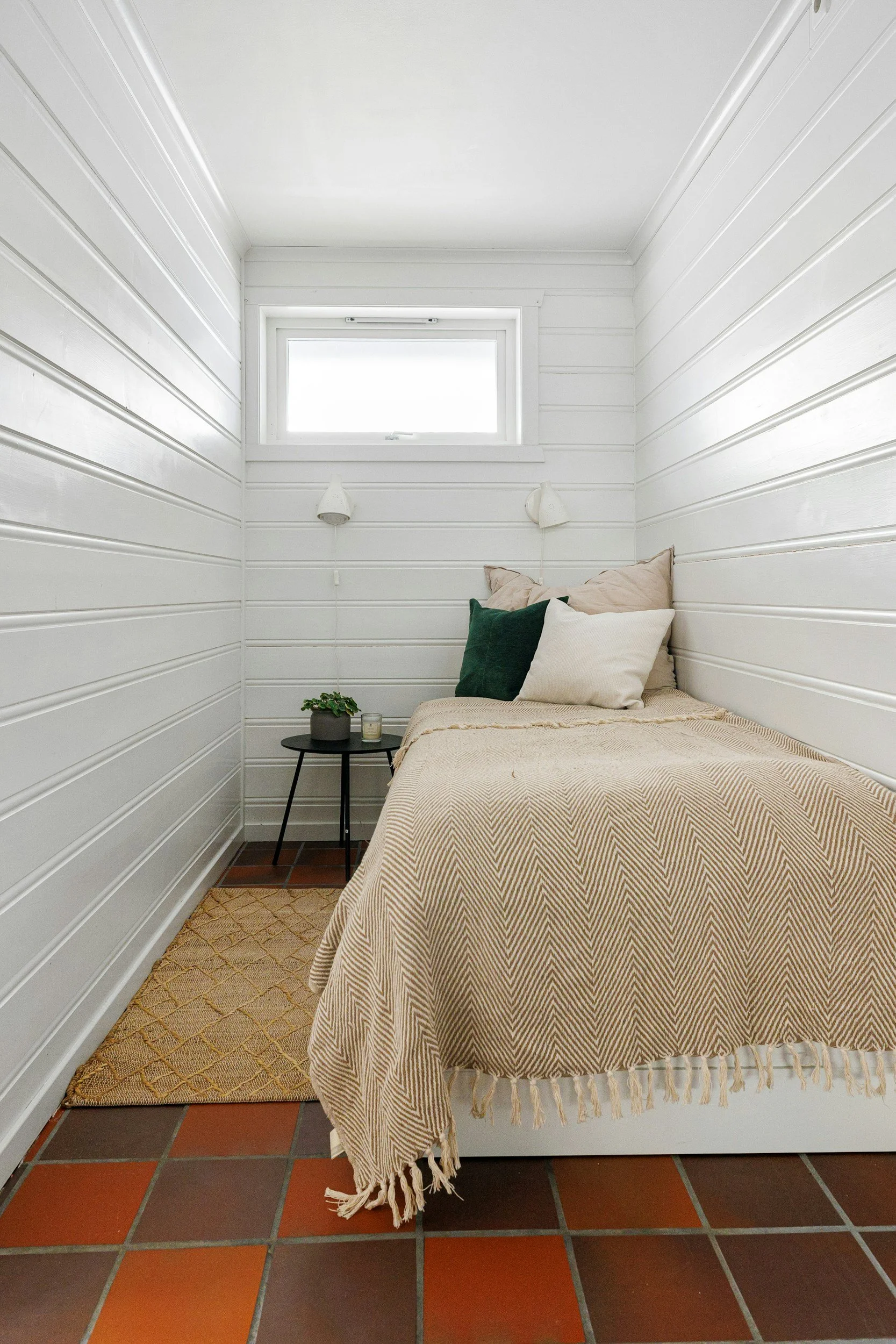 tiny house bedroom with white shiplap and tile floors