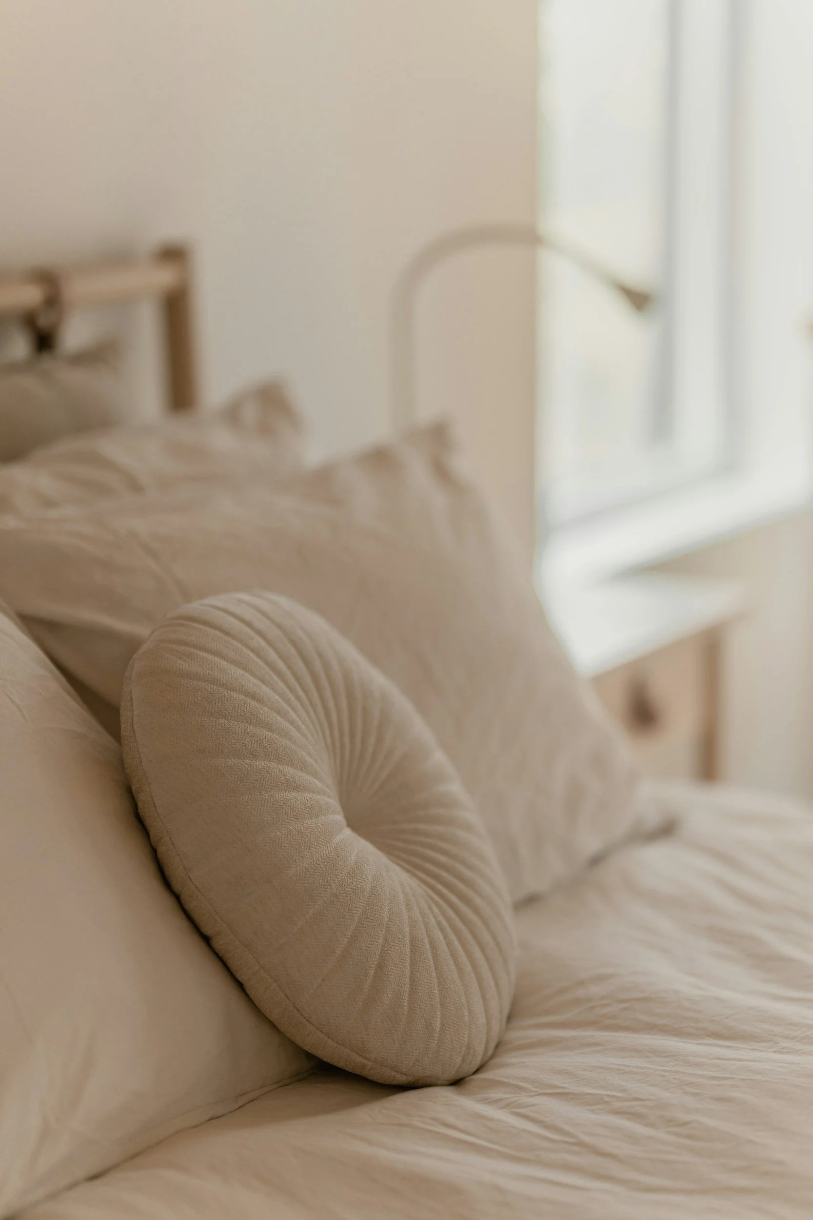 neutral beige linens and round pillow