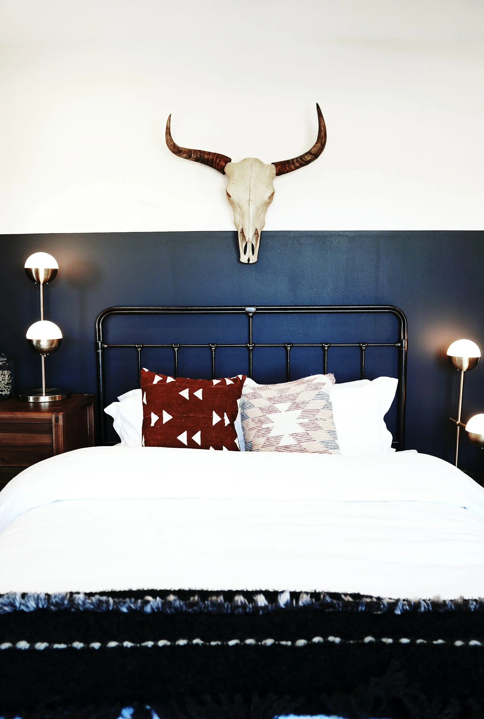 rustic bedroom with black accent wall and skull decor