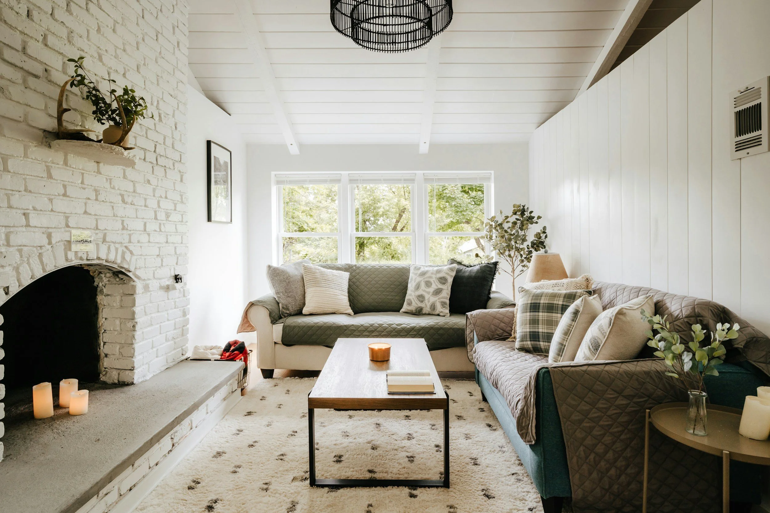 white living room with shiplap walls and white brick fireplace