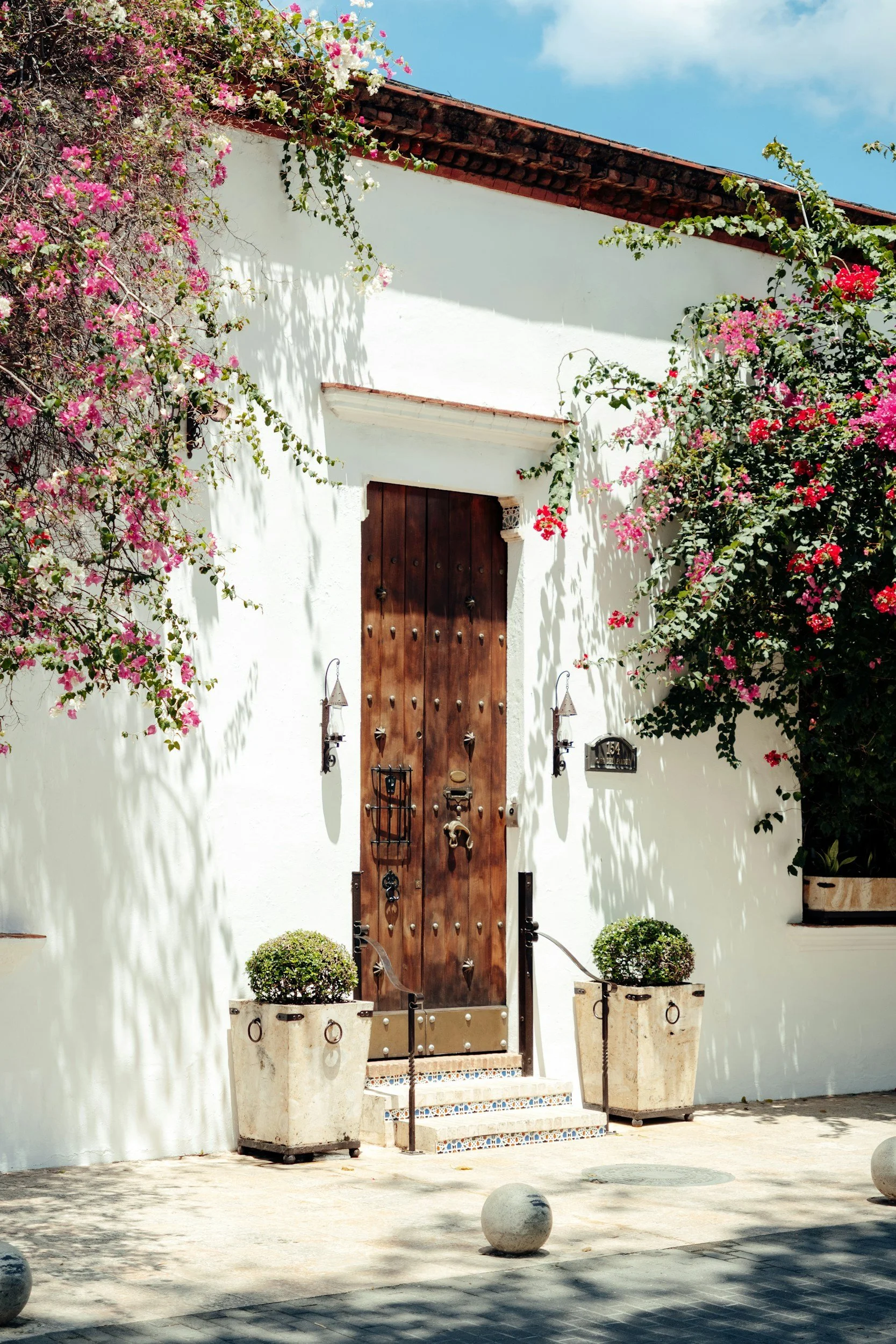 white house with vintage wood door and tile stairs