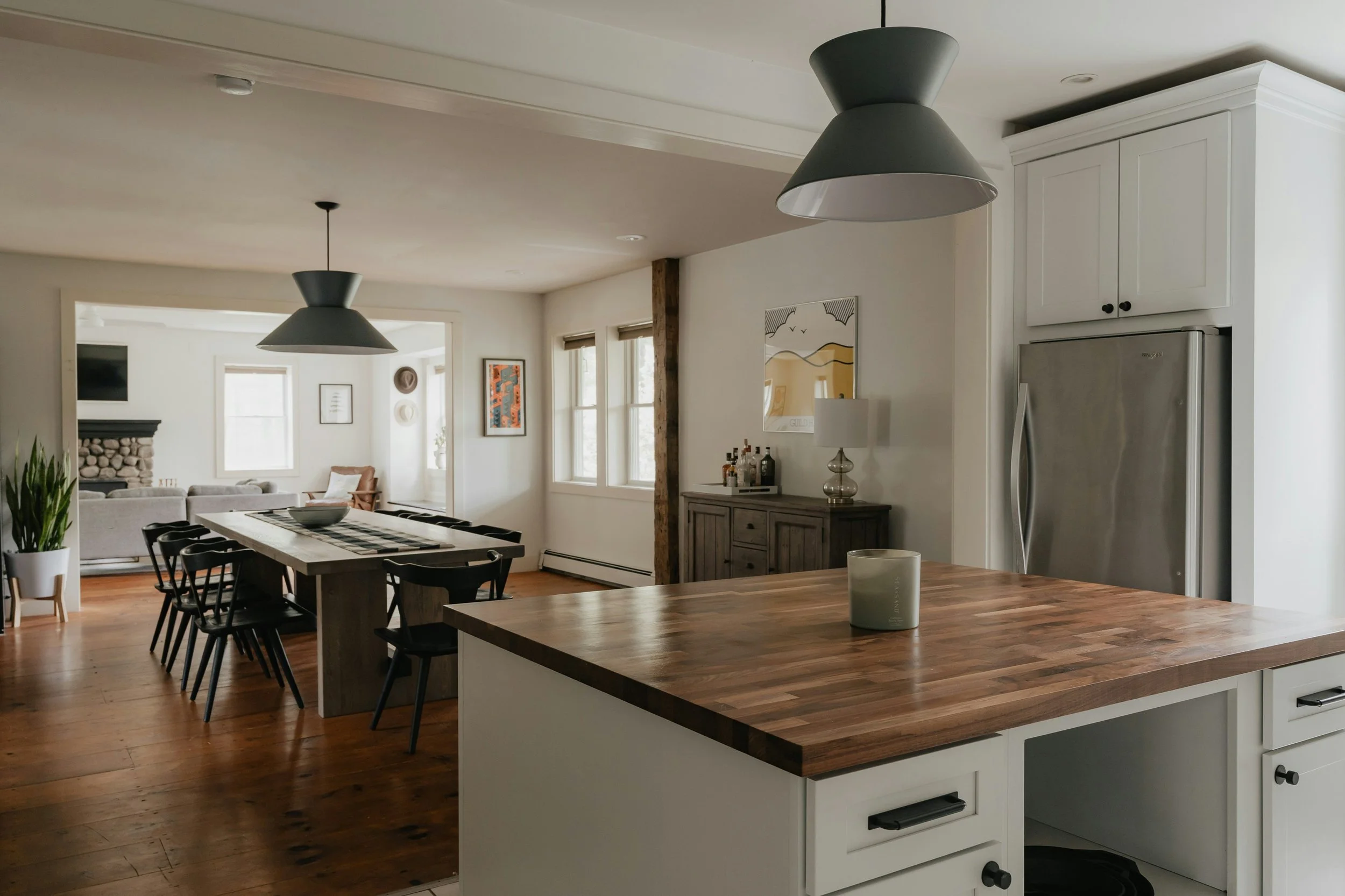 white kitchen with butcher block countertops and pendant lighting