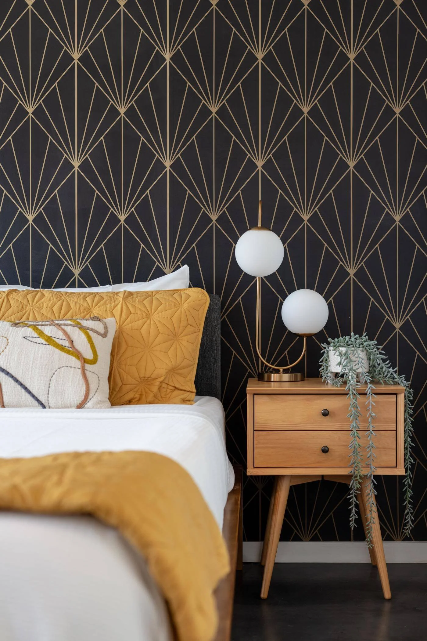 black and gold geometric wallpaper with yellow pillow and quilt