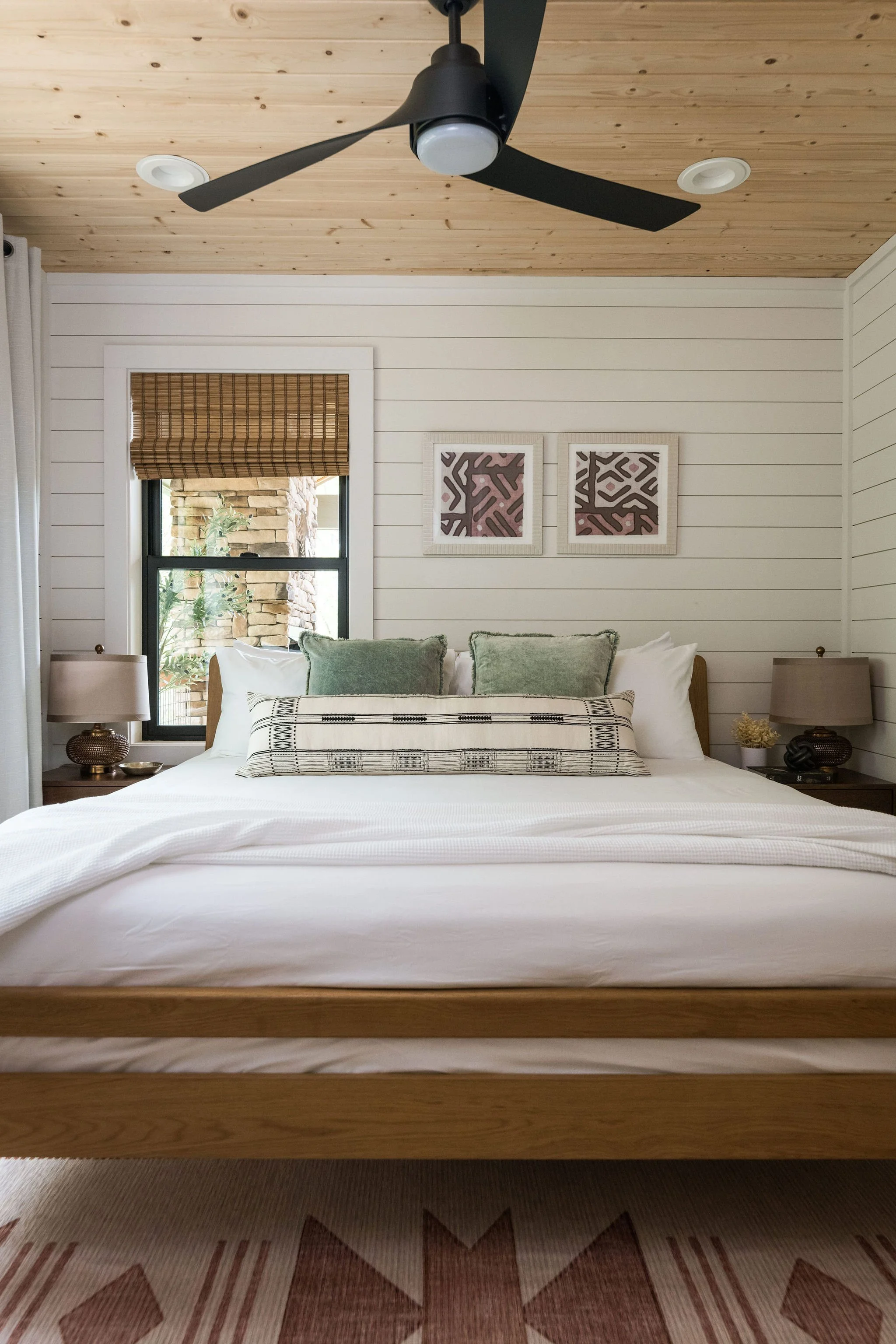 light bedroom with green throw pillows