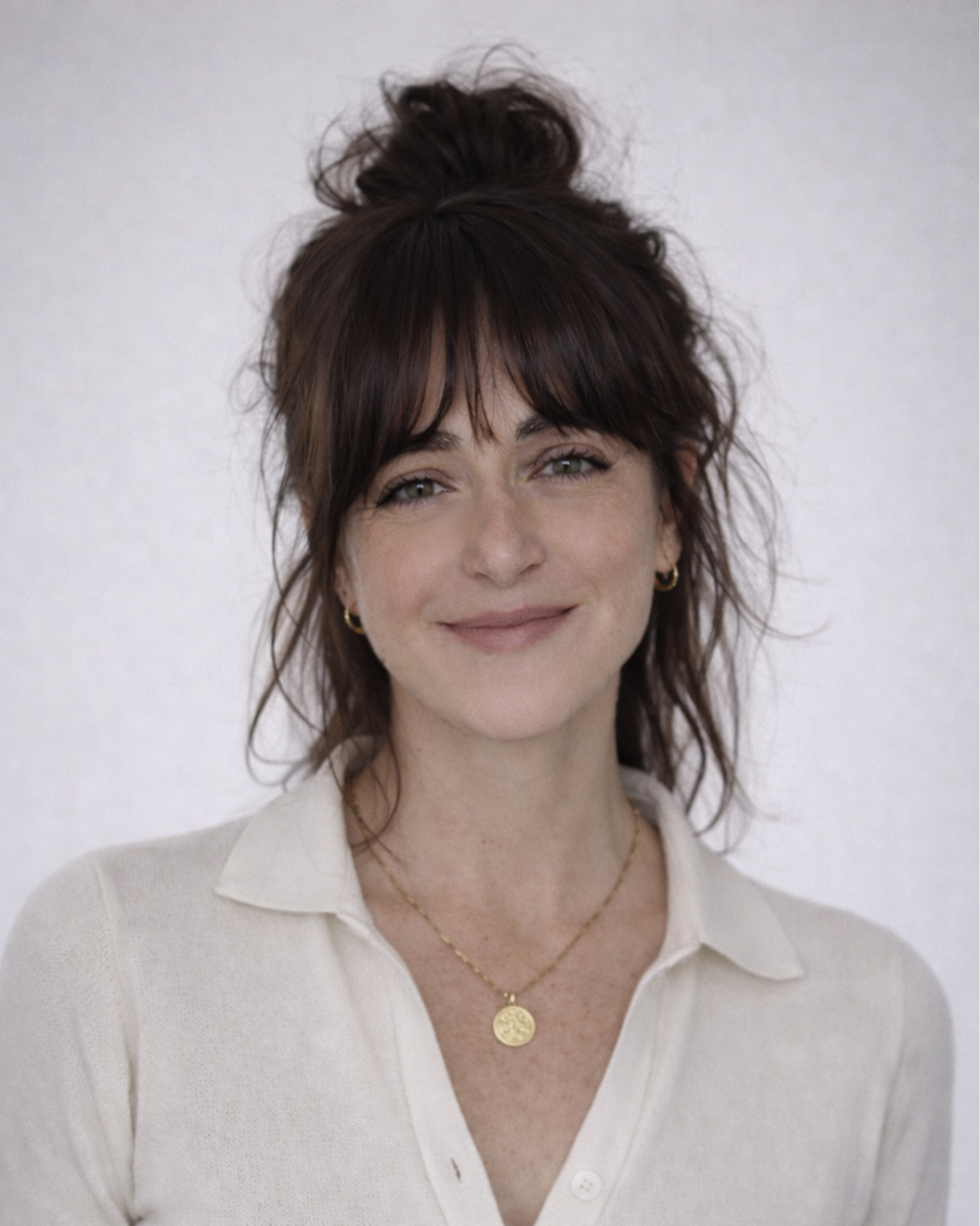 headshot of Sarah Bronstein of Sukkha Interior Design in a cream sweater and messy bun