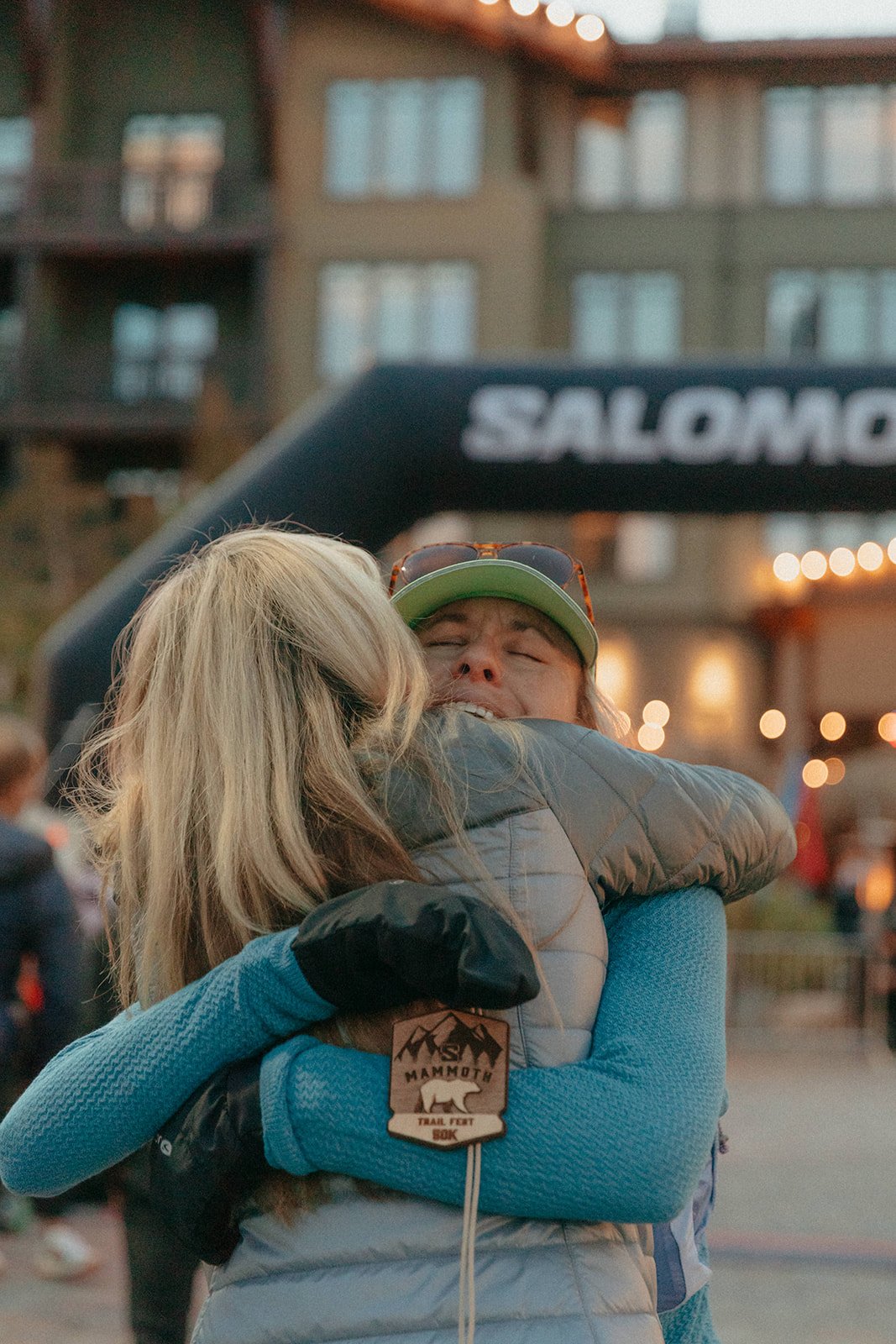 Two female runners hugging at the finish line