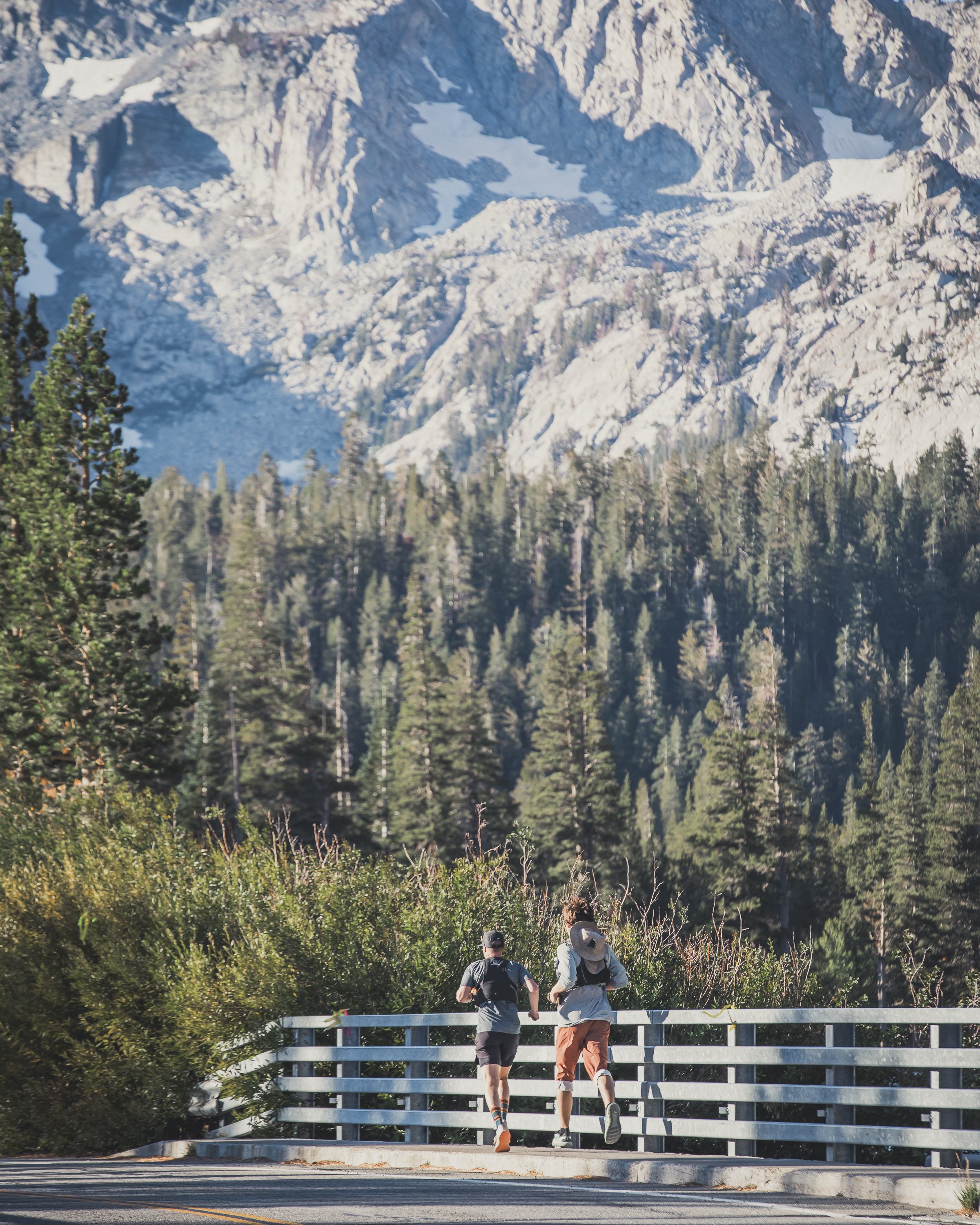 Two runners run across a bridge with the mountains ahead of them during mammoth trail fest