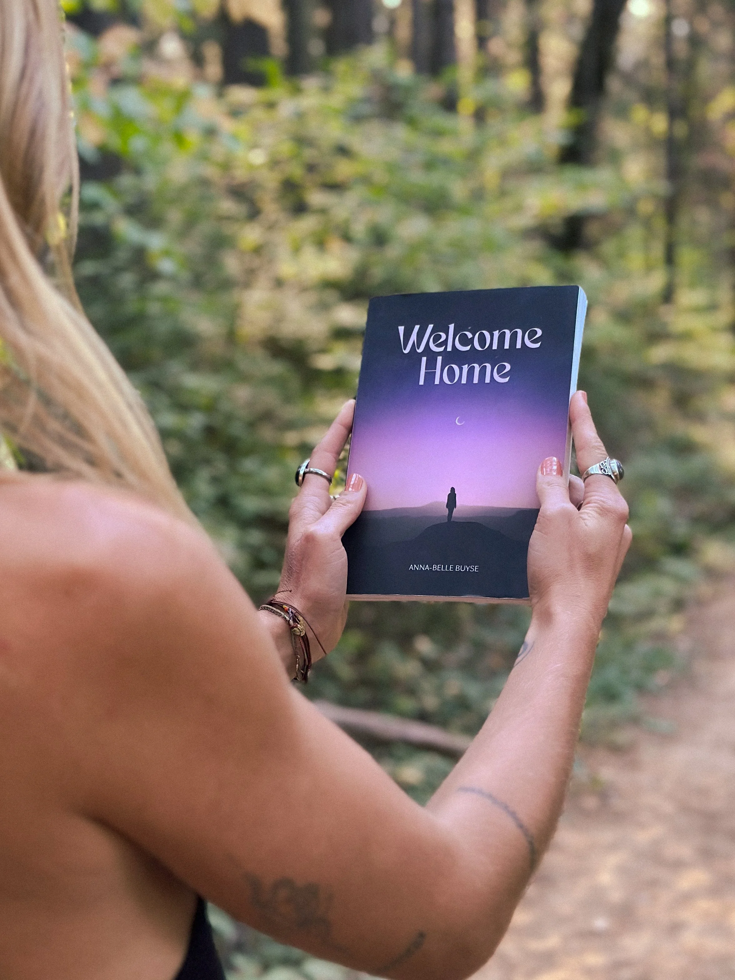 Anna-Belle Buyse holding her poetry book titled "Welcome Home"