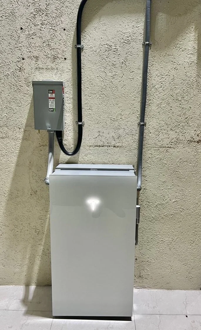 Tesla powerwall 3, metal throw handle isolator, Tesla expansion unit mounted on concrete wall