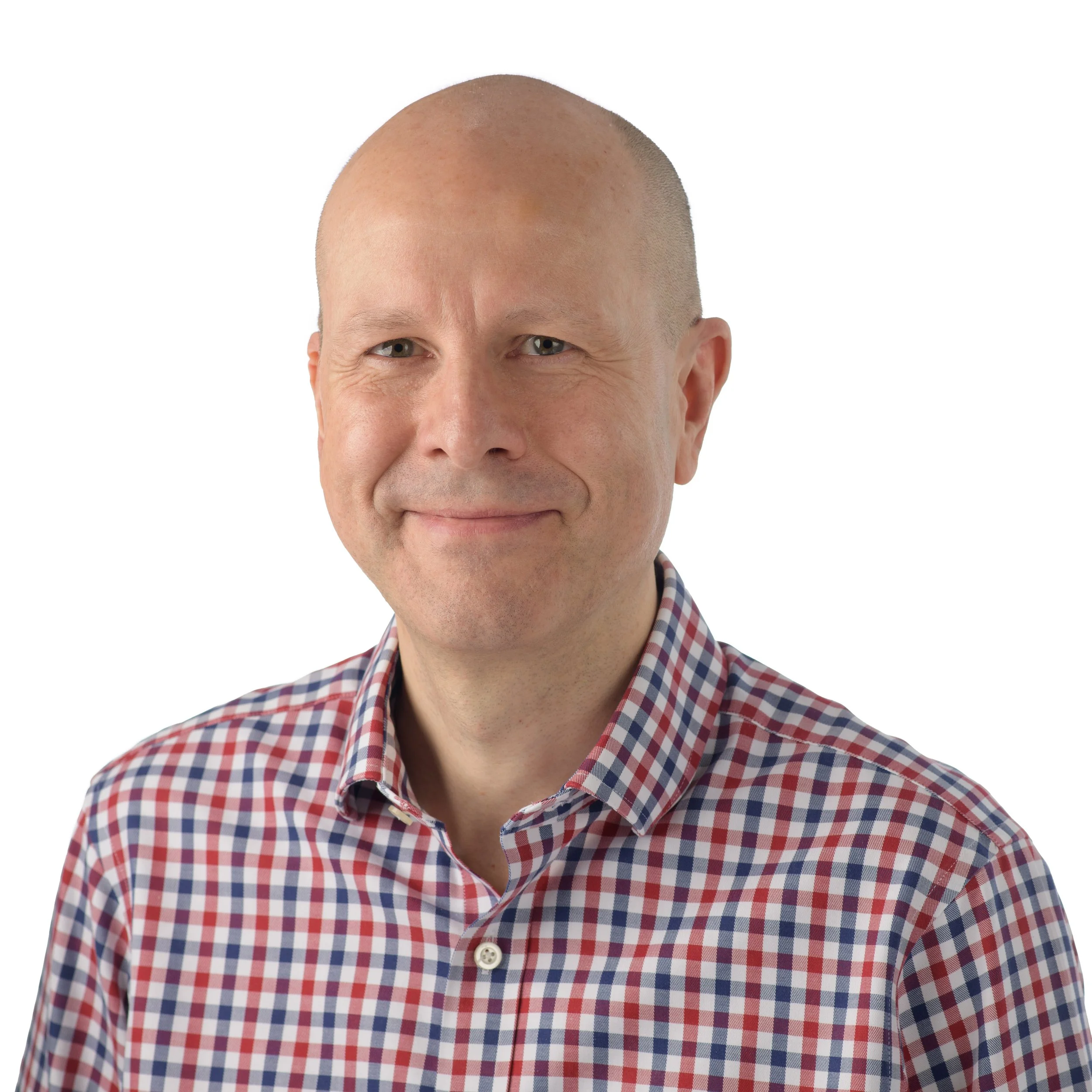 Portrait of a middle-aged man with a shaved head, wearing a red and white checkered shirt, smiling softly, against a plain white background.