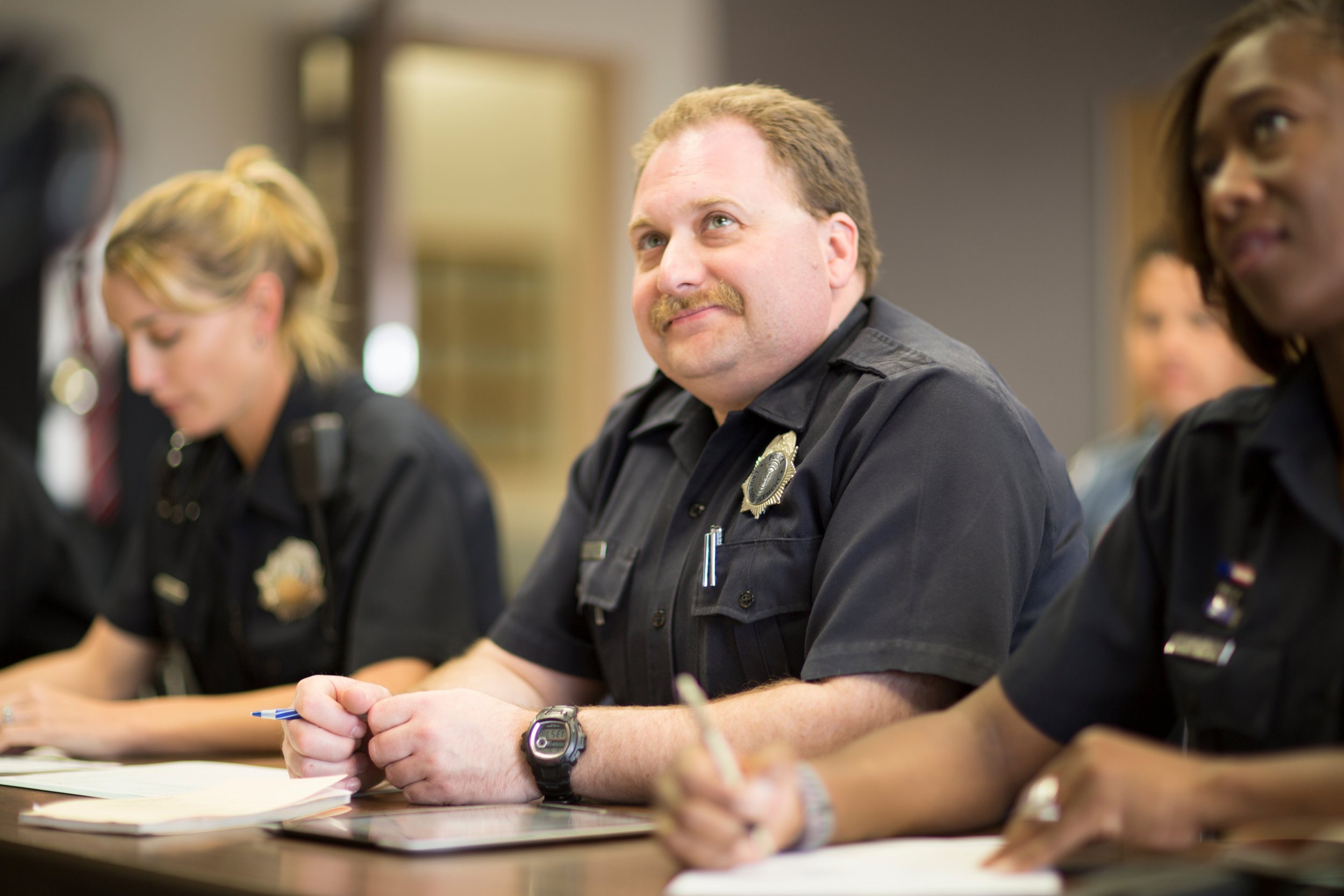 Officers at table: police officers participating in a training and discussion on behavioral health crisis response