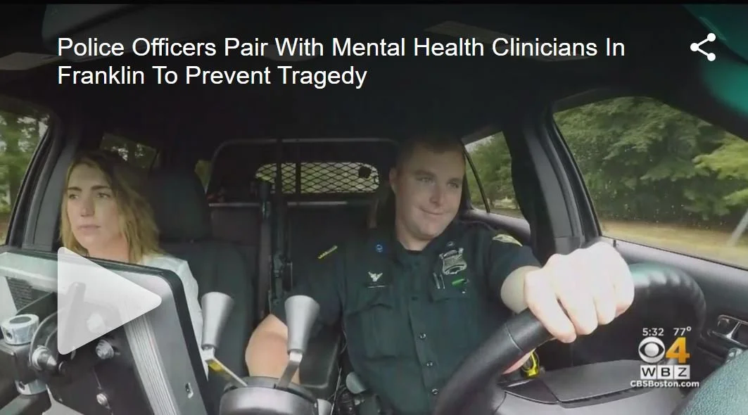 Police officers and mental health clinicians in a police car in Franklin, working together to prevent tragedy.