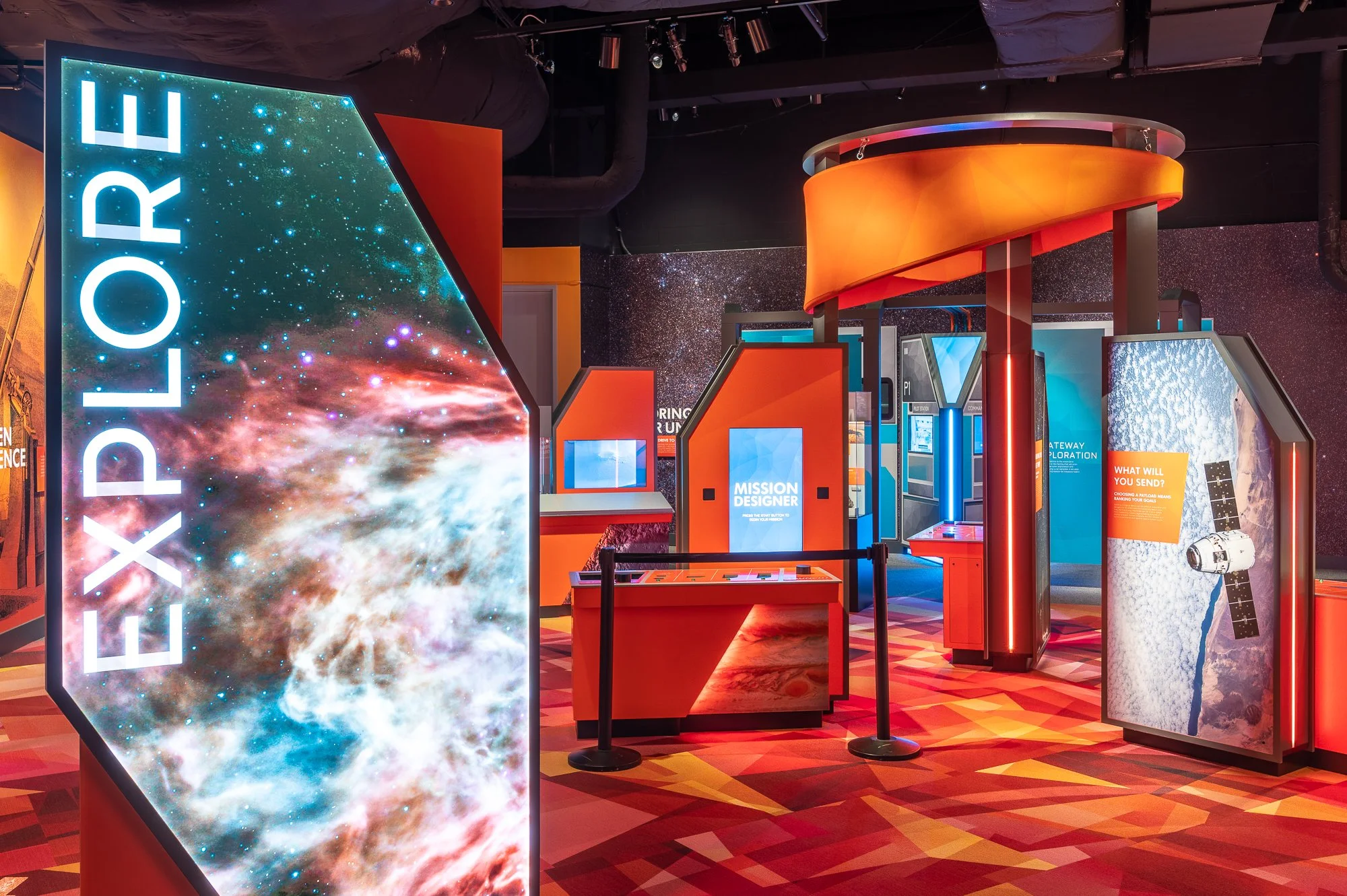 Interactive space-themed exhibit with colorful digital displays in a dark room