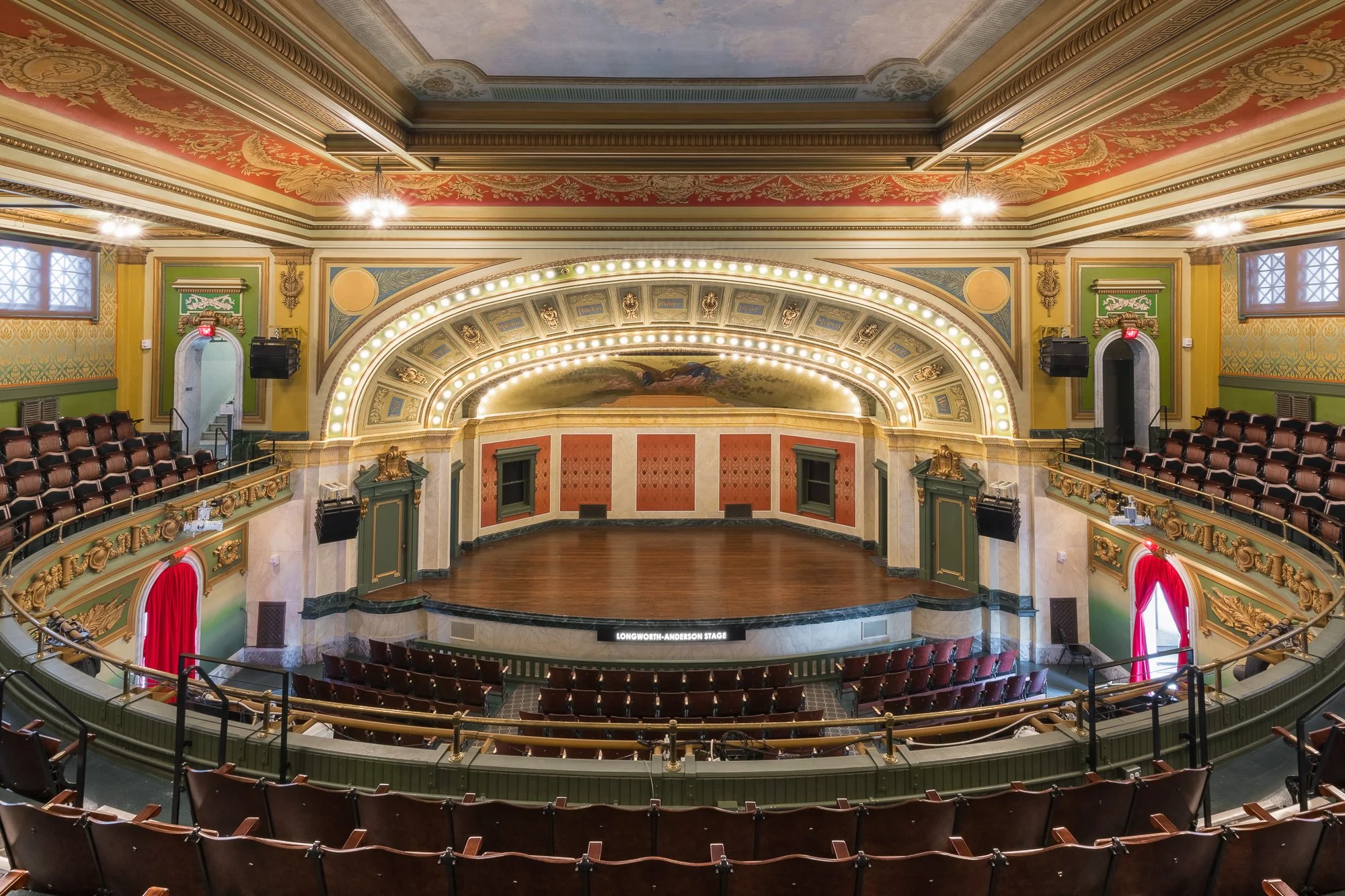 Interior view of Longworth-Anderson stage with ornate, colorful walls, decorative ceiling, and vintage theater seating.