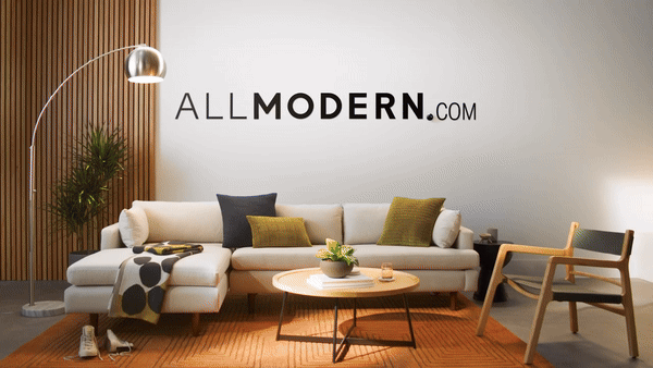 Modern living room with a white sectional sofa, colorful pillows, wooden coffee table, and lamp, featuring the text 'ALLMODERN.com' on the wall.