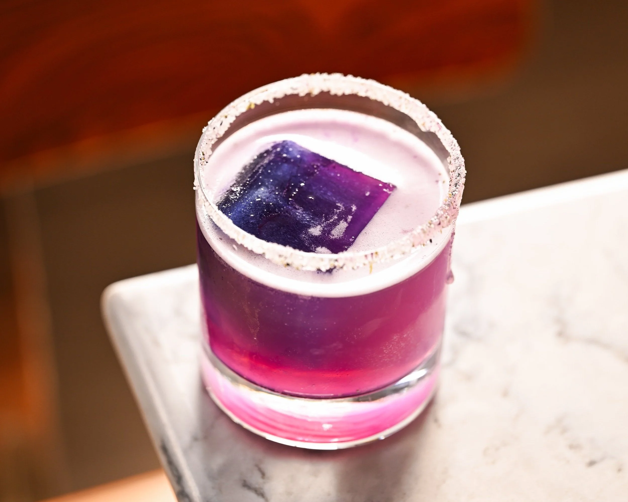 Purple signature cocktail with a sugared rim at The Poynt bar, Newburyport MA