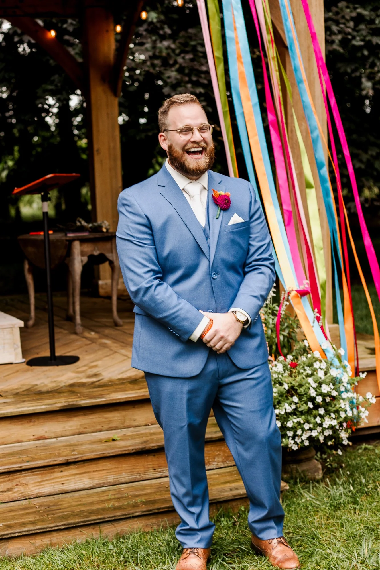 Groom standing at the alter with an expression of joy and surprise and seeing his bride walk down the aisle