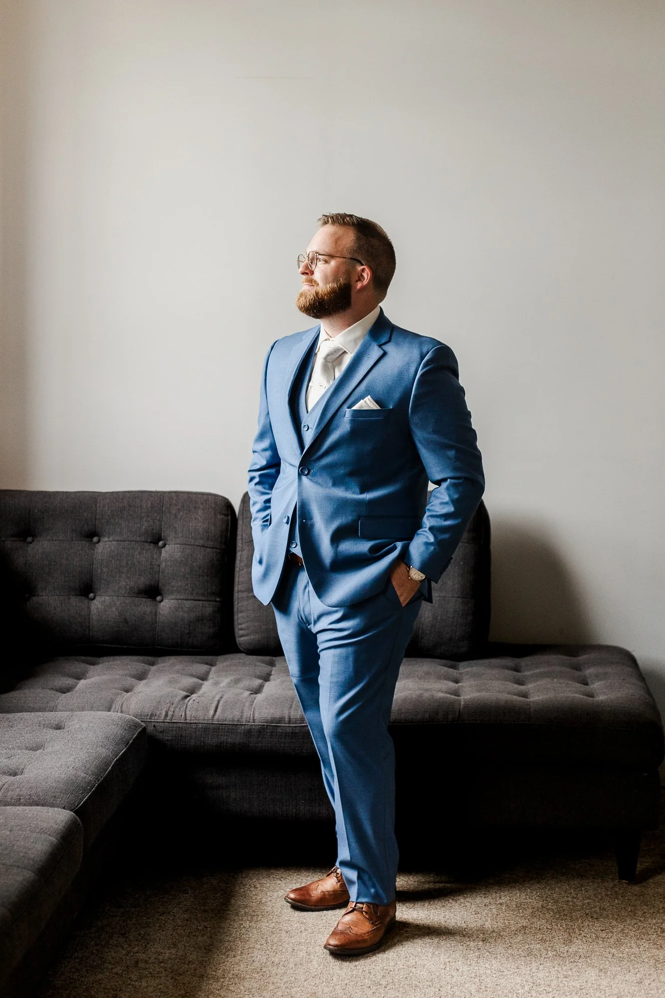 Full body portrait of groom in a blue tux on his wedding day