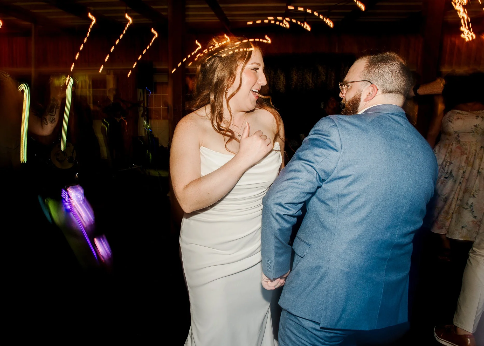 Bride and groom dancing together on a dark dance floor