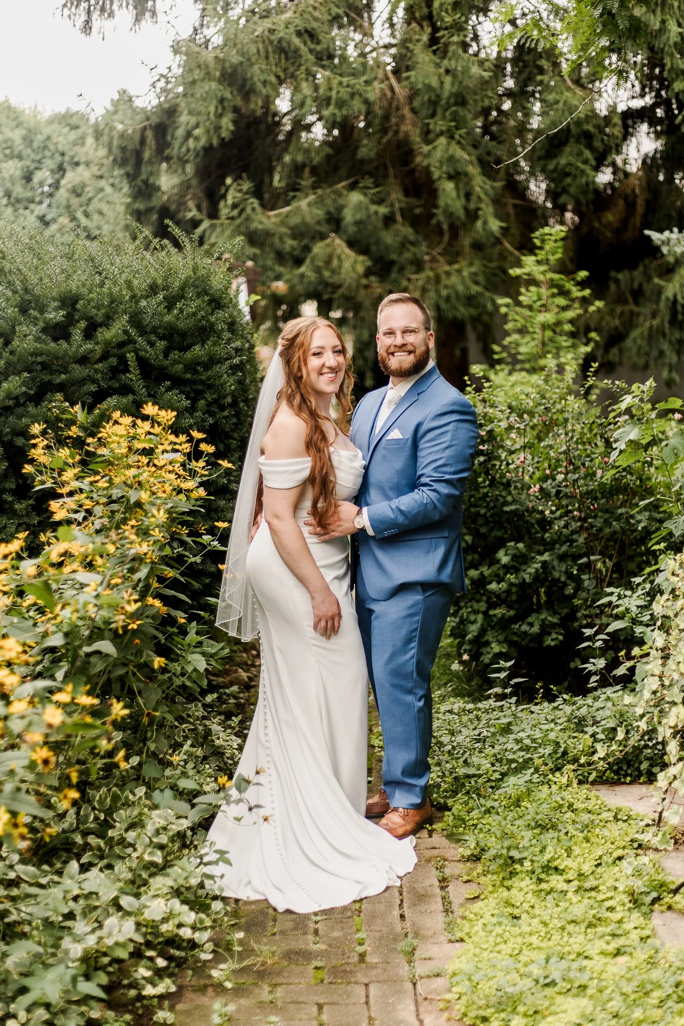 Portrait of bride and groom smiling at Bloom and Bower in Risingsun Ohiohe camera in a flowering garden at
