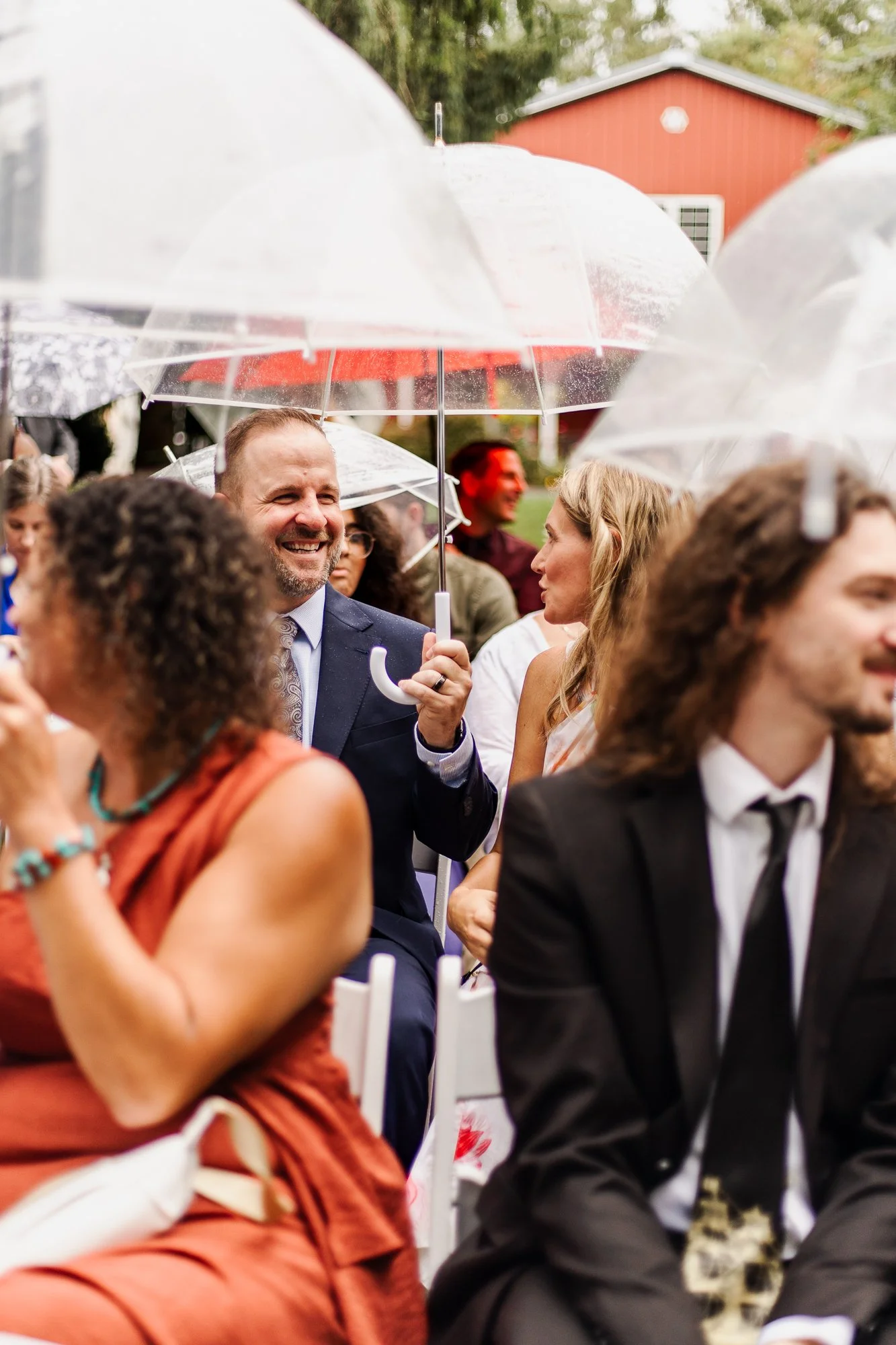Guests carrying umbrellas while they wait at the ceremony site at bloom and bower in rising sun ohio