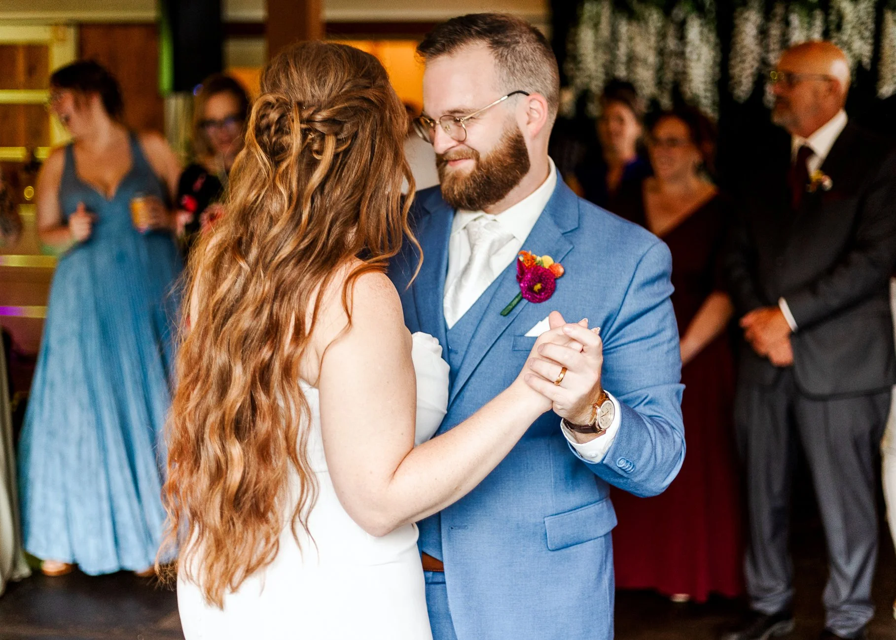 close up of bride and groom dancing their first dance with groom smiling warmly at the bride